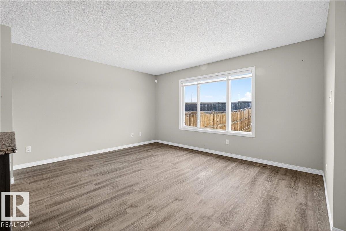 This room features light-colored walls and wood-look flooring - 17023 38 Street Nw, Edmonton, AB - Indoor Photo Showing Other Room