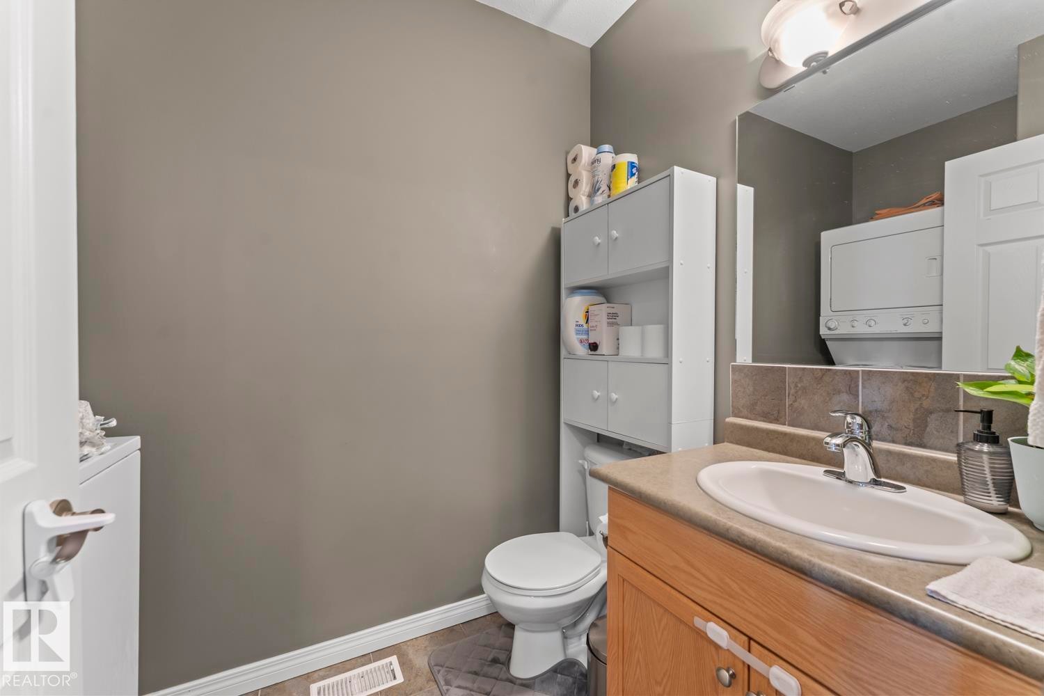 The property features a bathroom with a vanity, an integrated sink, a faucet, and a mirror - 107 801 11 Street, Cold Lake, AB - Indoor Photo Showing Bathroom