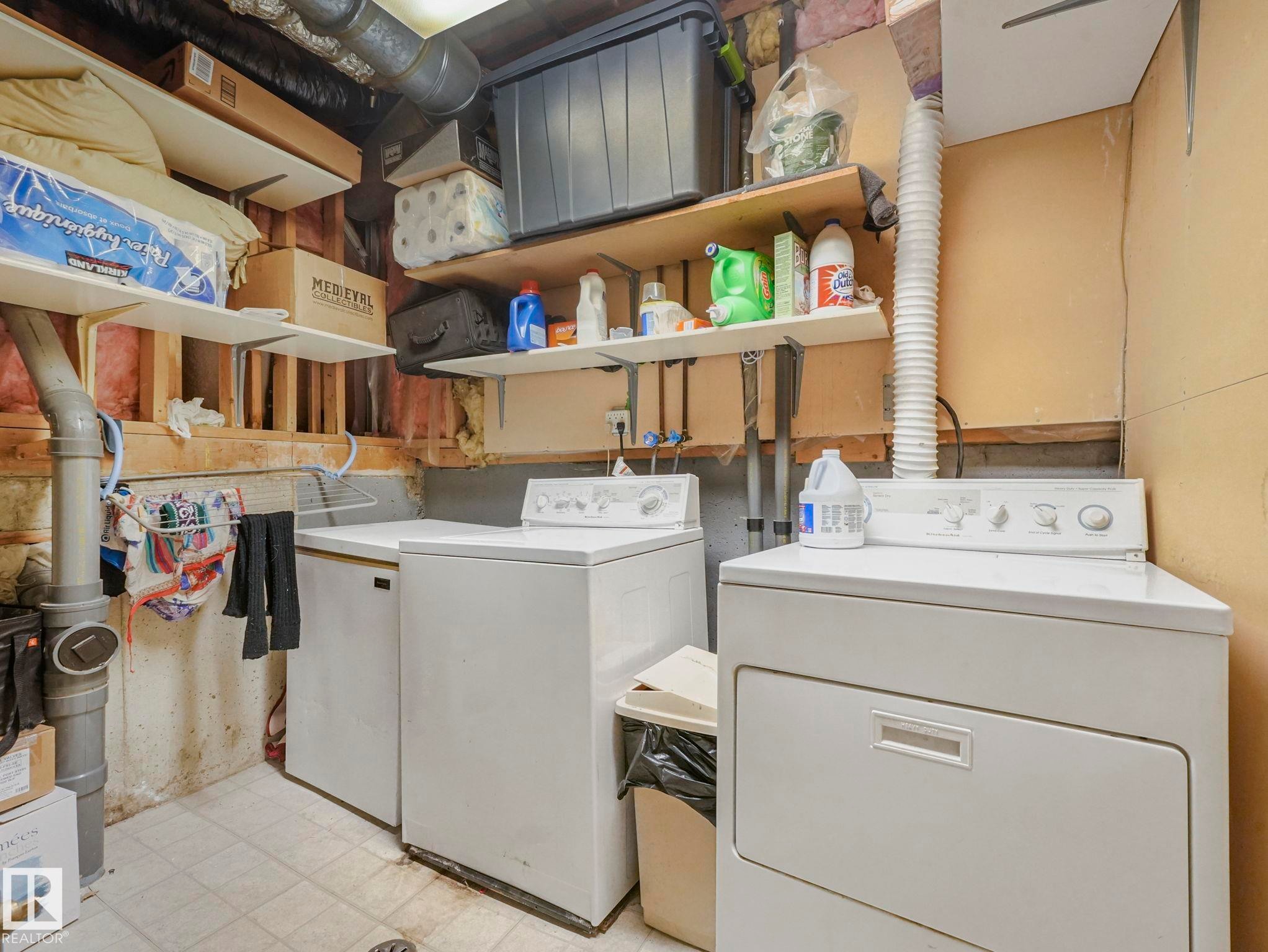 Laundry area featuring a washer and dryer, tiled flooring, and wall-mounted shelving - 4105 41 Avenue, Edmonton, AB - Indoor Photo Showing Laundry Room