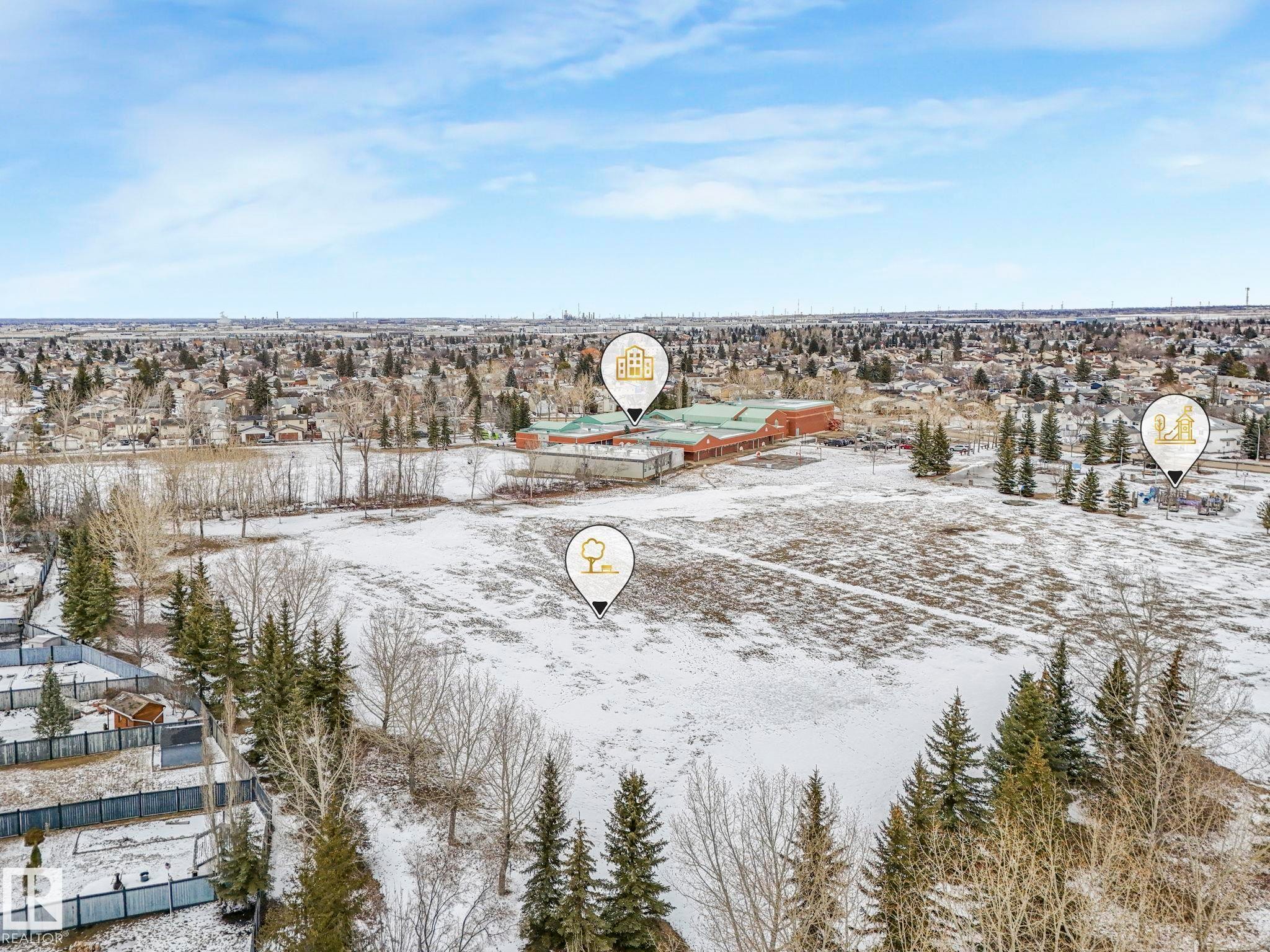 Expansive aerial view of the property and its surrounding area, featuring open land, scattered trees, and distant urban development under a clear sky - 4105 41 Avenue, Edmonton, AB - Outdoor With View