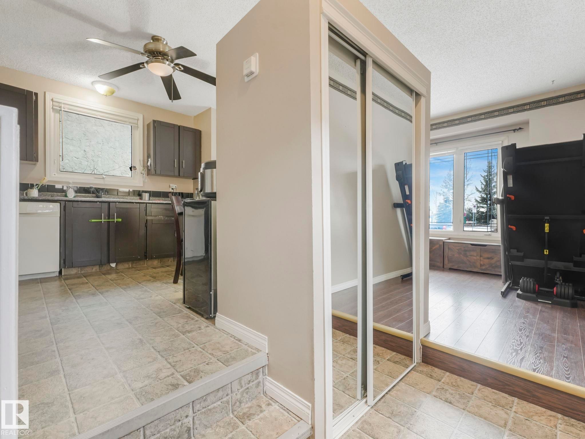 The property features a kitchen with tile flooring, dark cabinetry, and white appliances - 4105 41 Avenue, Edmonton, AB - Indoor Photo Showing Other Room
