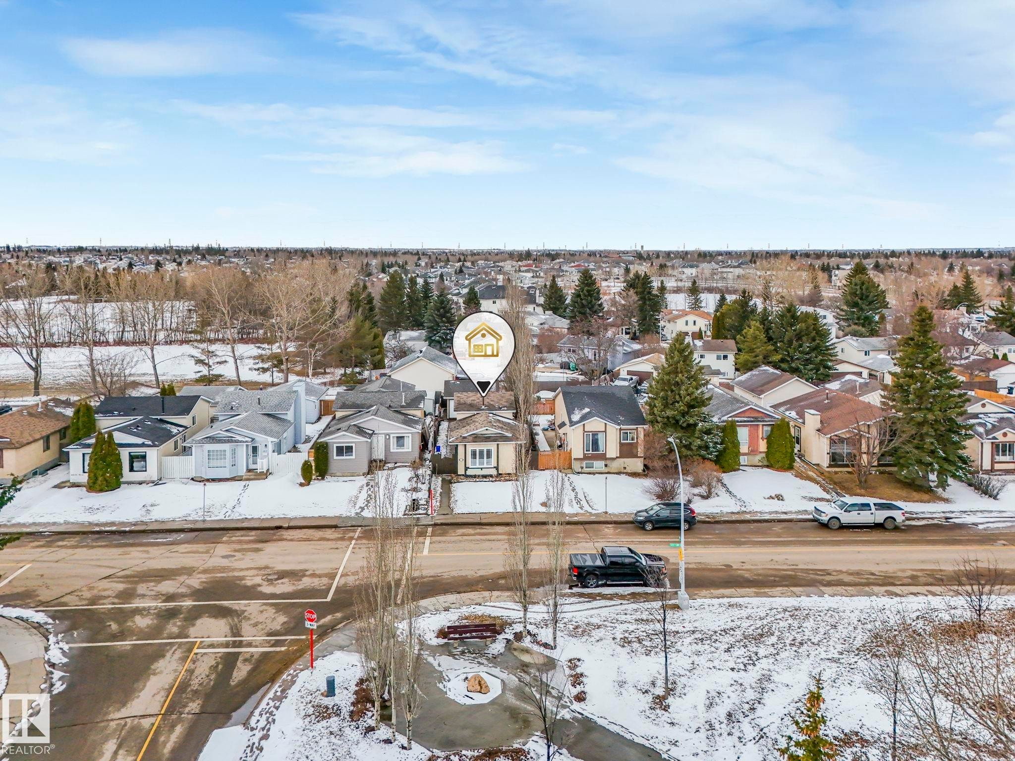Aerial view showcasing the property within a residential setting, featuring nearby houses, mature trees, and open land - 4105 41 Avenue, Edmonton, AB - Outdoor With View