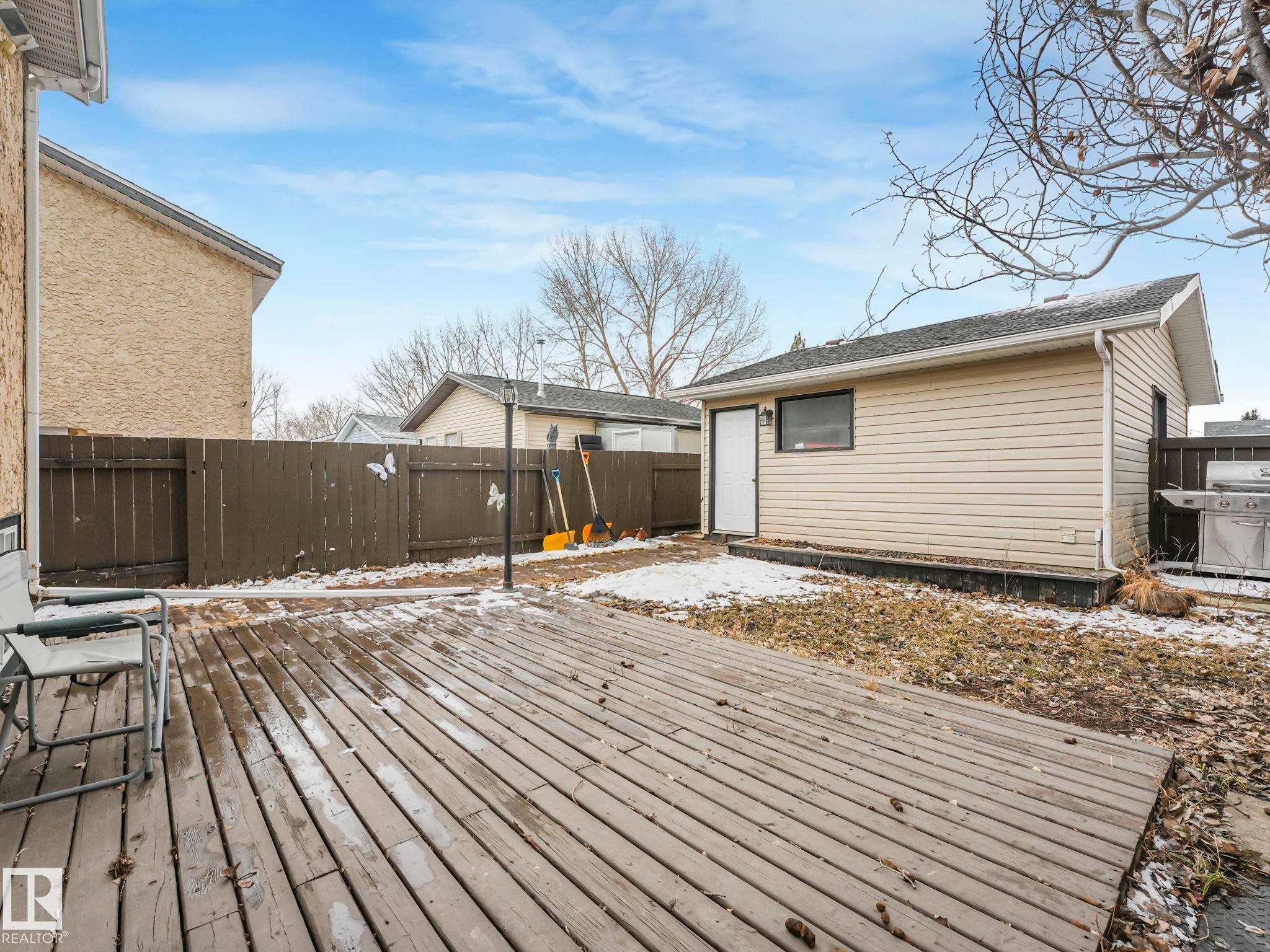 The property features a spacious wooden deck and a separate storage shed with siding - 4105 41 Avenue, Edmonton, AB - Outdoor With Exterior
