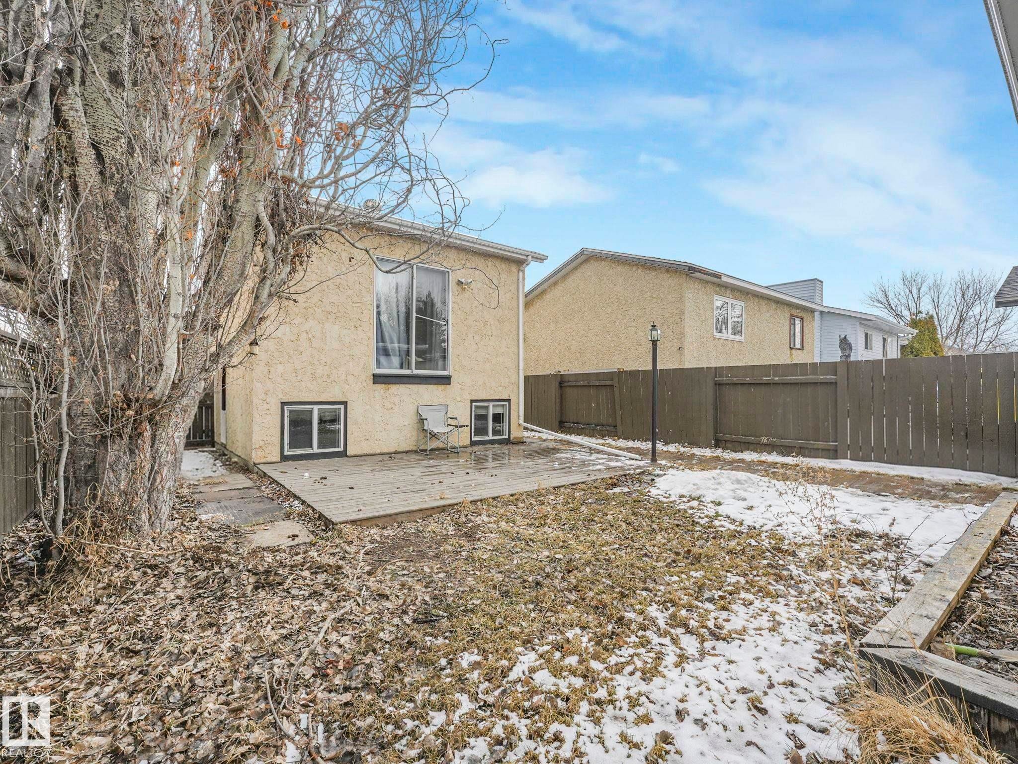 The property features a backyard with a wooden deck and a fence - 4105 41 Avenue, Edmonton, AB - Outdoor
