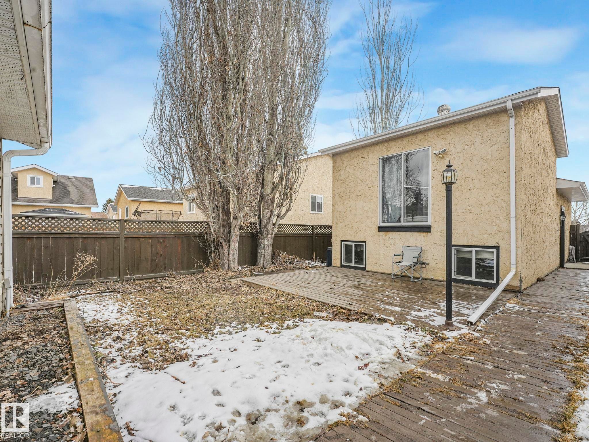 The property features a stucco exterior, a large rear window, and lower level windows - 4105 41 Avenue, Edmonton, AB - Outdoor