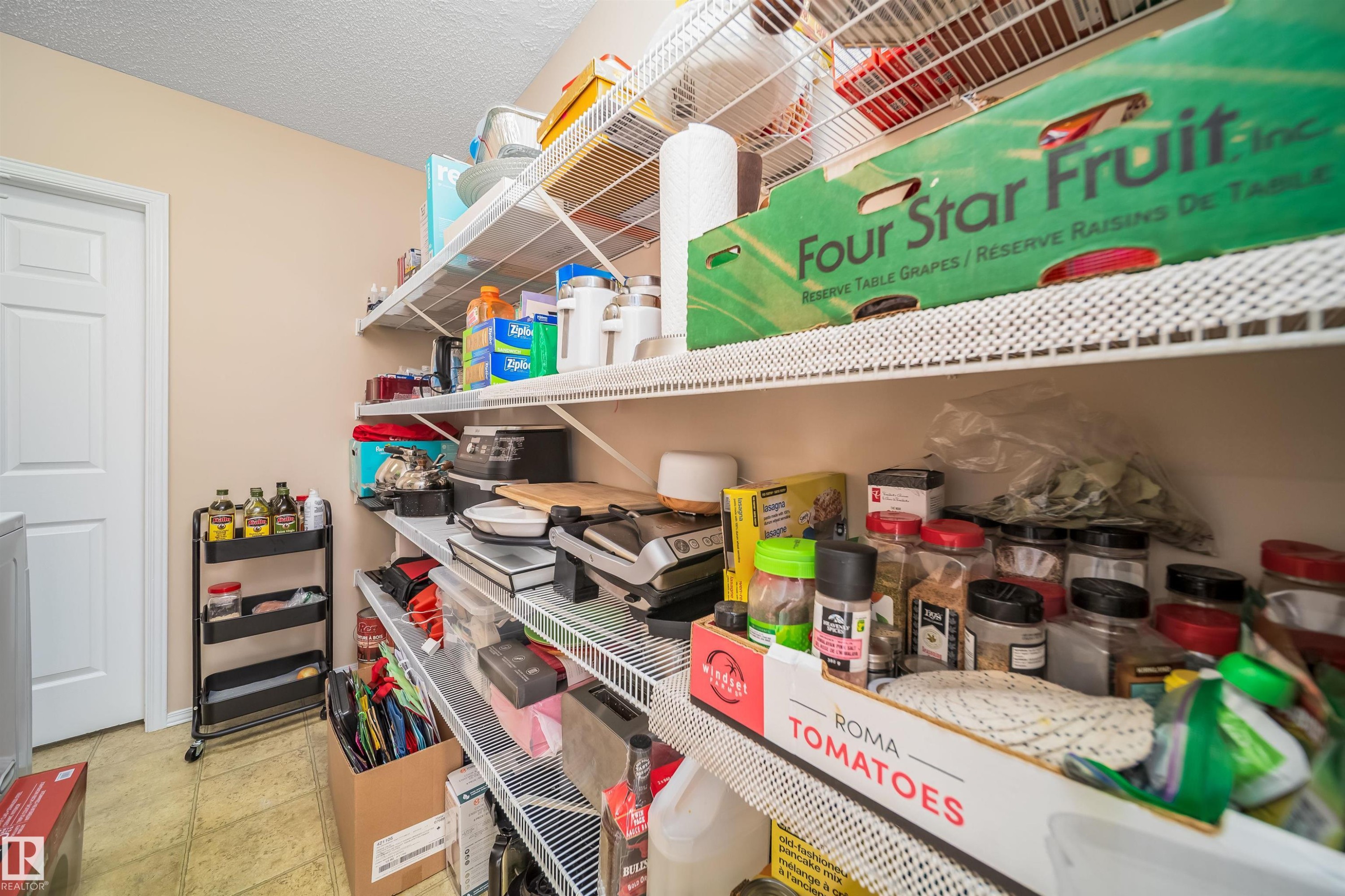 This room features extensive wire shelving providing generous storage solutions, complemented by a light-colored wall and a light-colored floor - 8932 175 Avenue, Edmonton, AB - Indoor With Storage