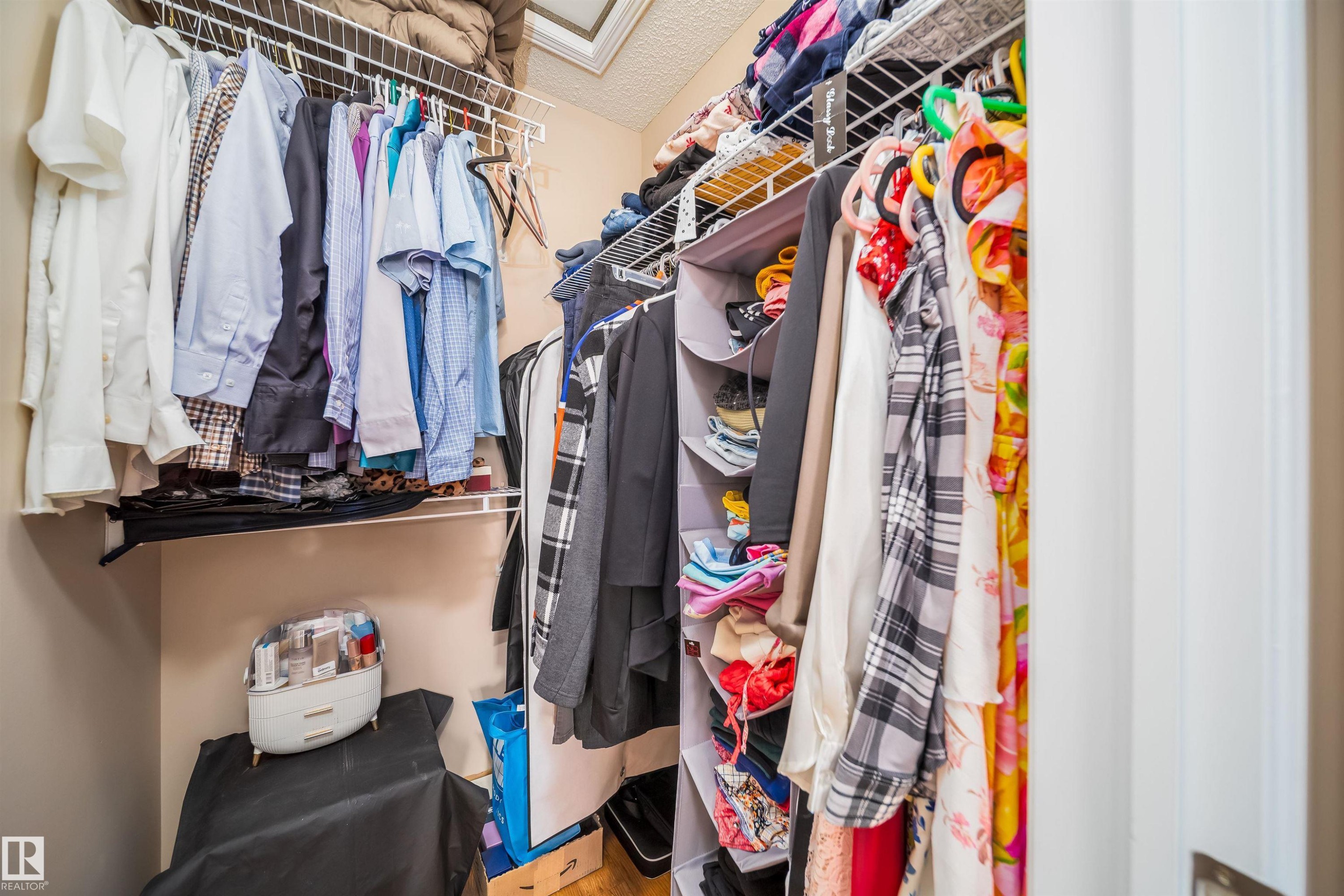 This closet features wall-mounted wire shelving and hanging rods, providing practical storage solutions - 8932 175 Avenue, Edmonton, AB - Indoor With Storage