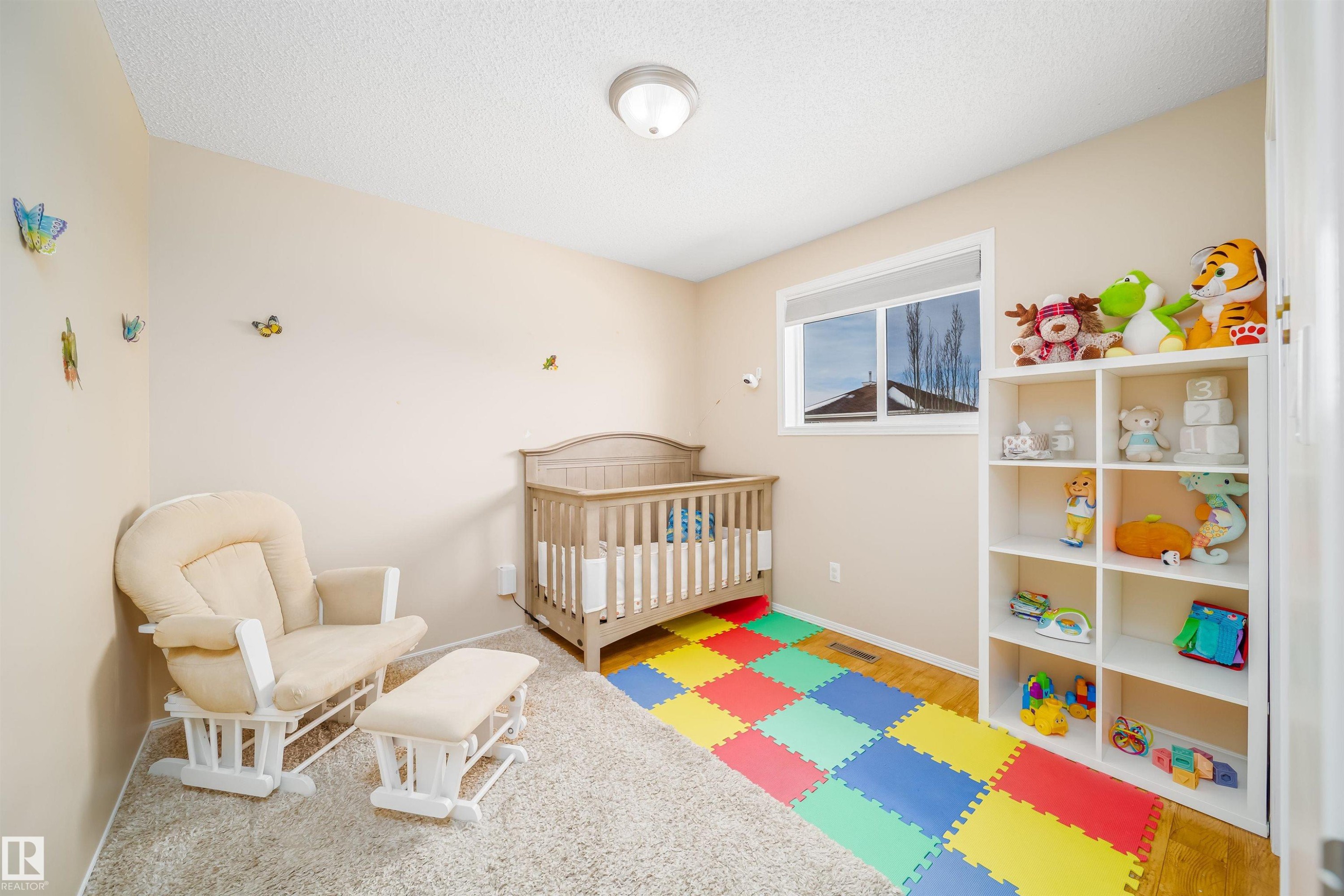 This room features a window providing natural light, a neutral wall color, and a textured ceiling - 8932 175 Avenue, Edmonton, AB - Indoor Photo Showing Bedroom