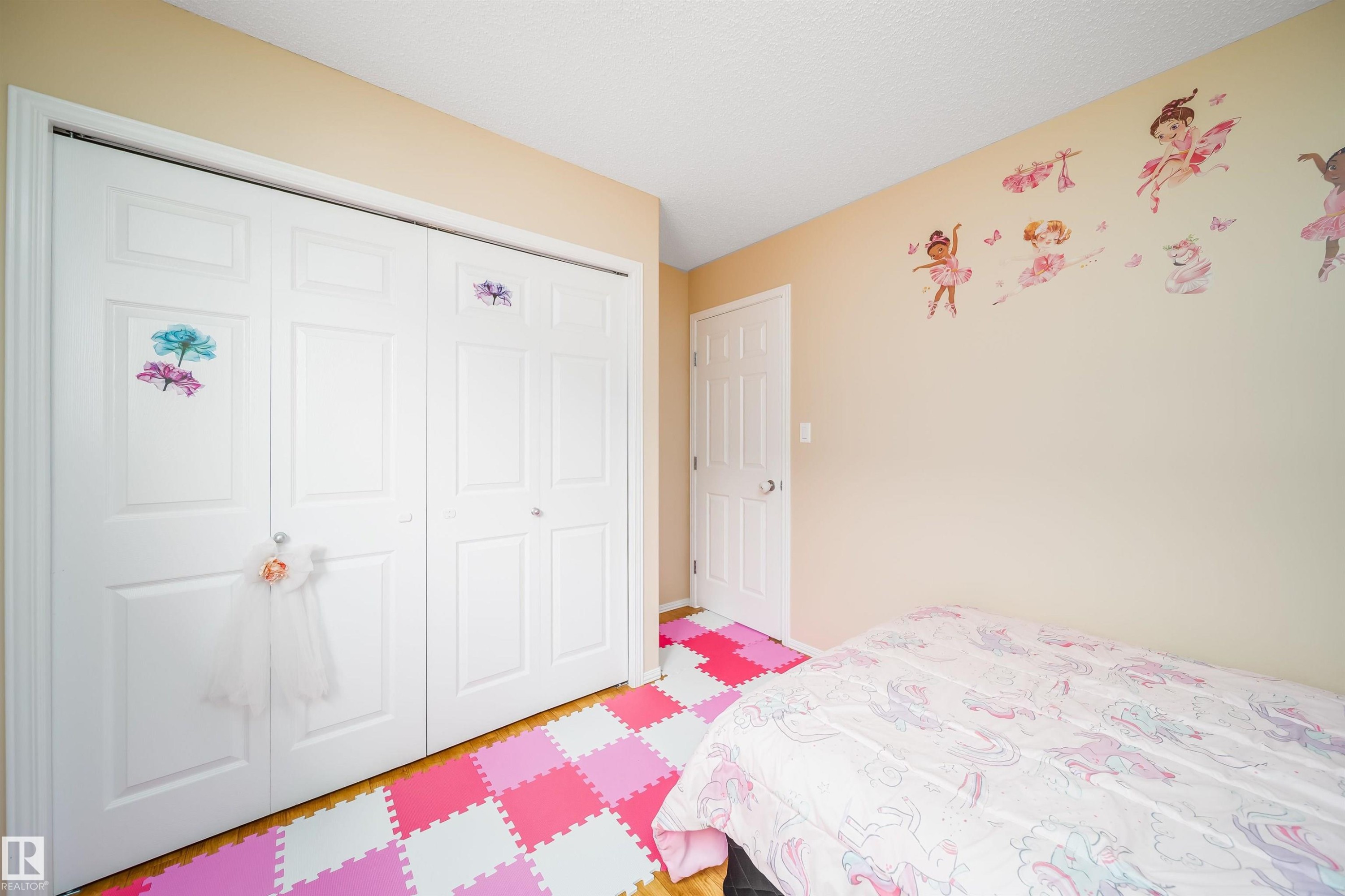 This room features light-toned walls and a white door, complemented by white bi-fold closet doors - 8932 175 Avenue, Edmonton, AB - Indoor Photo Showing Bedroom