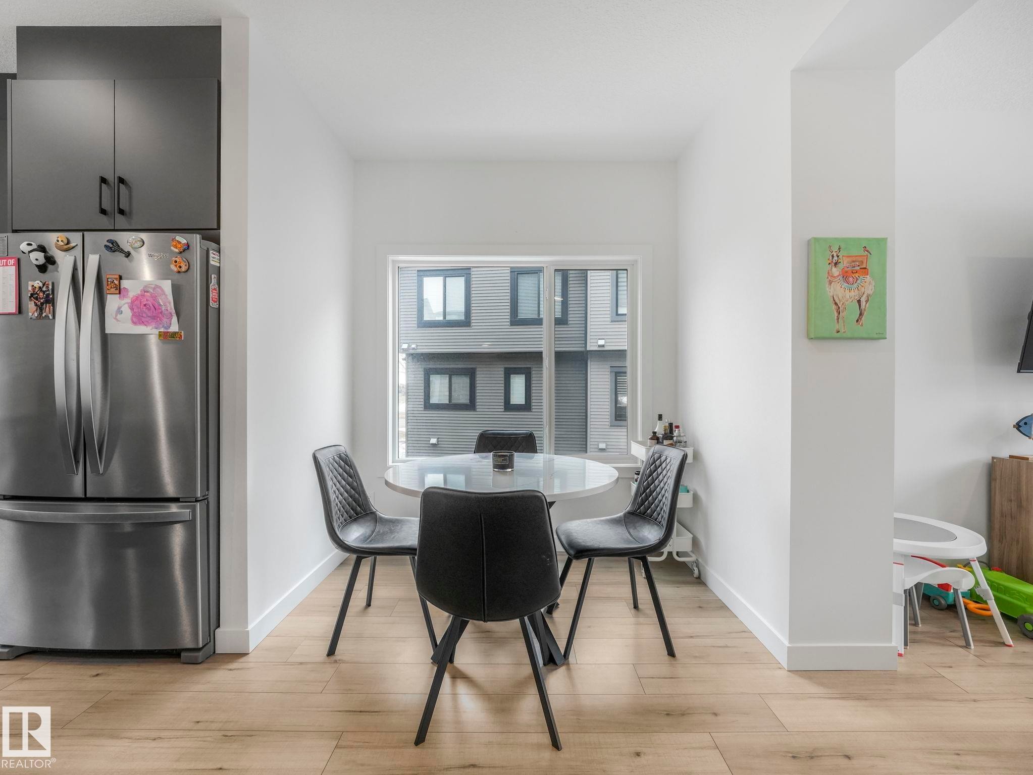 Dining area featuring light-toned flooring, a window providing natural light, and a column - 95 1010 Rabbit Hill Road, Edmonton, AB - Indoor Photo Showing Dining Room