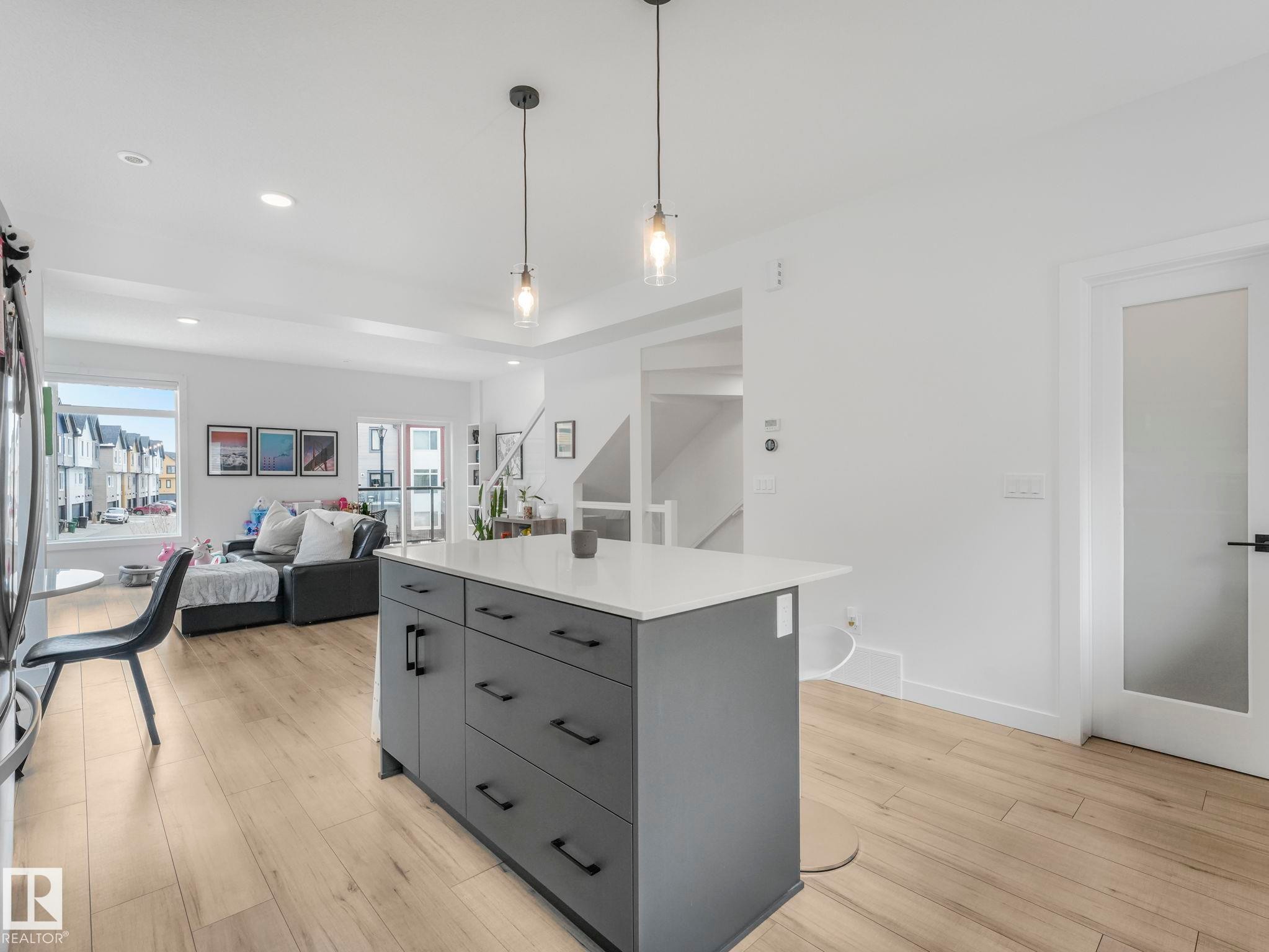 The open-concept living area features light wood-style flooring and recessed lighting - 95 1010 Rabbit Hill Road, Edmonton, AB - Indoor