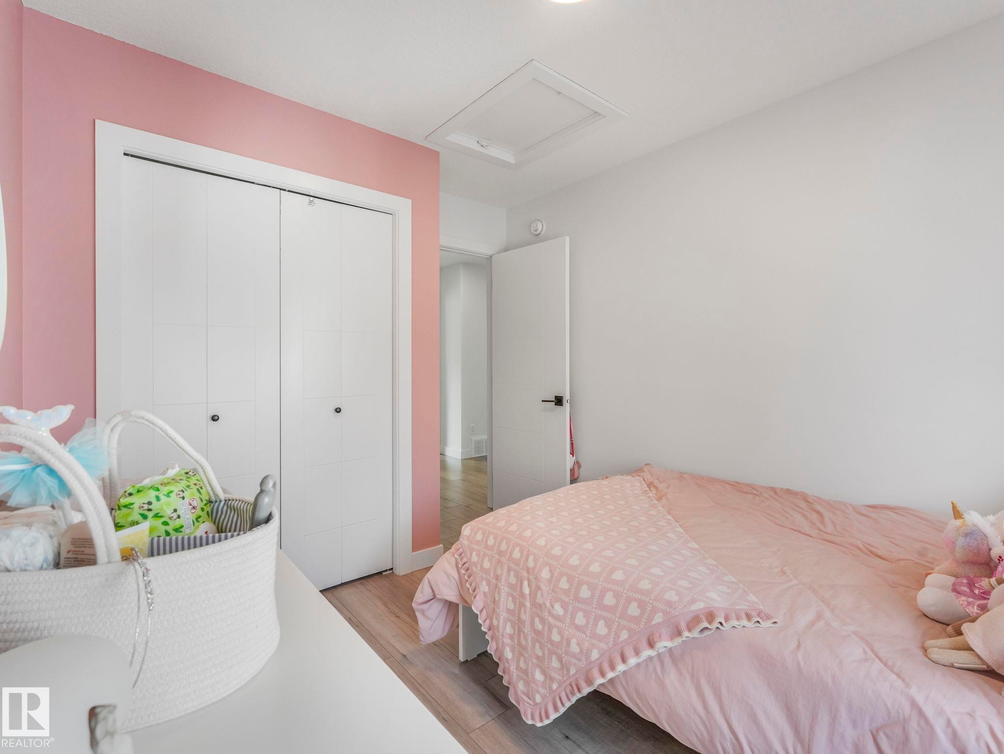 This room features light wood-look flooring and a closet with bi-fold doors - 95 1010 Rabbit Hill Road, Edmonton, AB - Indoor Photo Showing Bedroom