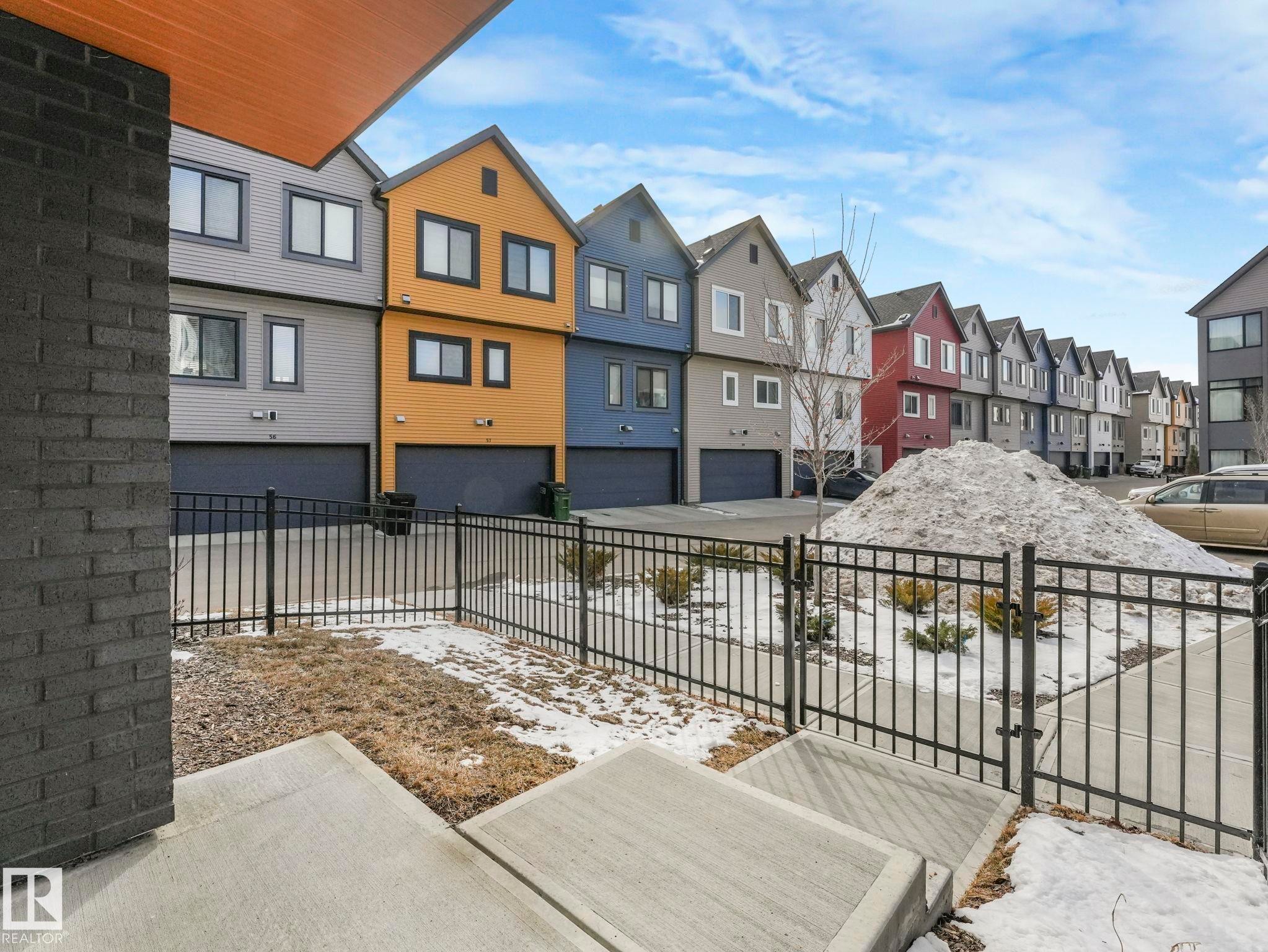 The property features a modern exterior with a black brick facade and a contrasting wood soffit - 95 1010 Rabbit Hill Road, Edmonton, AB - Outdoor