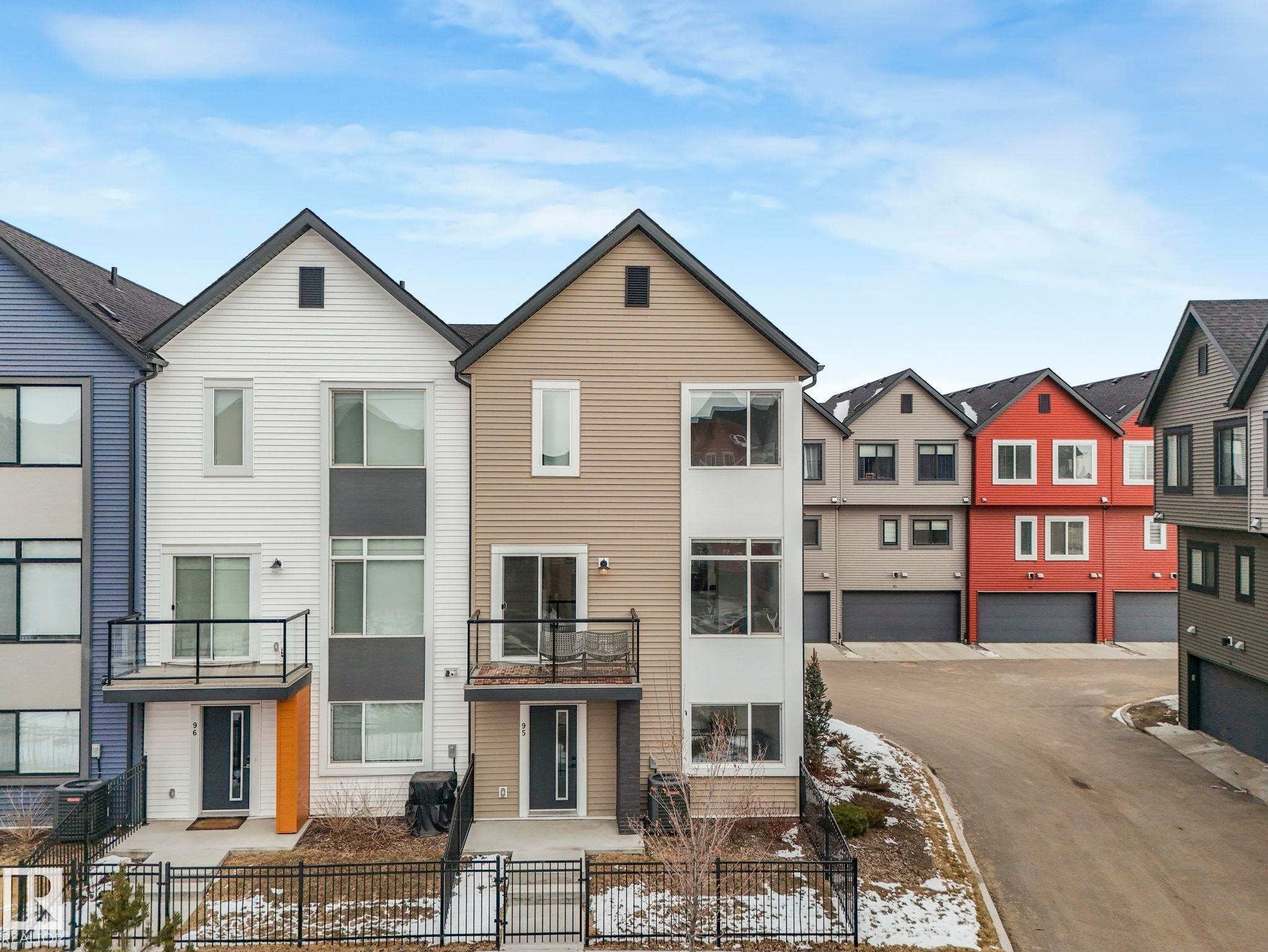 This property features a modern exterior with a mix of siding types and colors, including white, tan, and blue - 95 1010 Rabbit Hill Road, Edmonton, AB - Outdoor With Facade