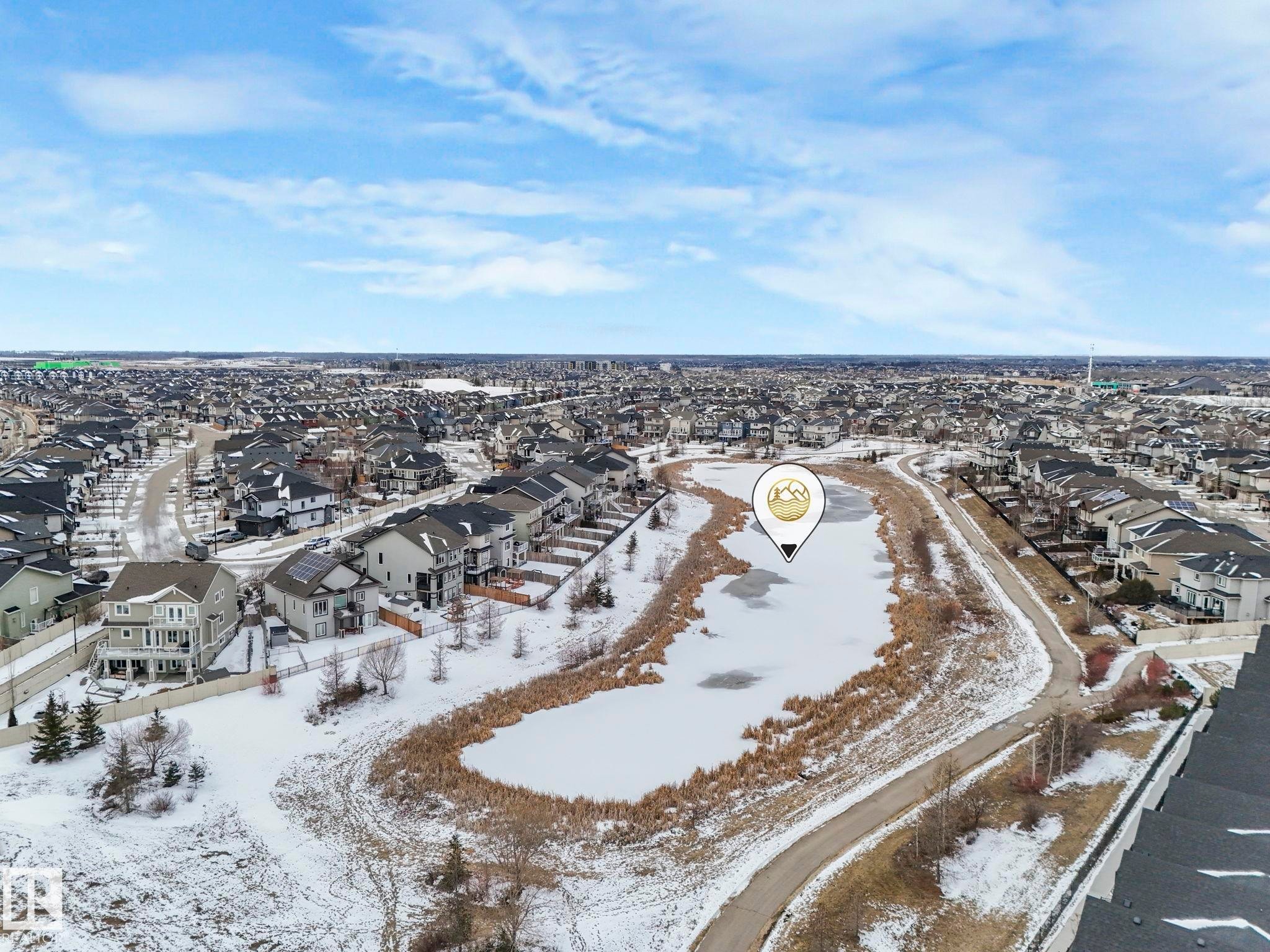 This property is situated within a developed residential area, featuring a winter landscape with snow-covered ground and a frozen body of water - 95 1010 Rabbit Hill Road, Edmonton, AB - Outdoor With View