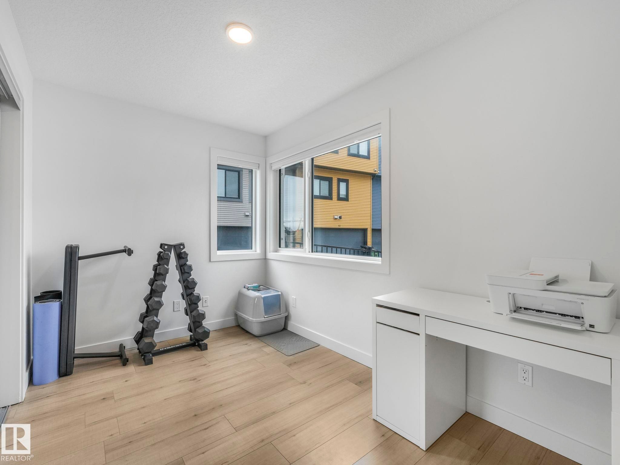 This room features light wood-style flooring and white walls, creating a bright and airy atmosphere - 95 1010 Rabbit Hill Road, Edmonton, AB - Indoor