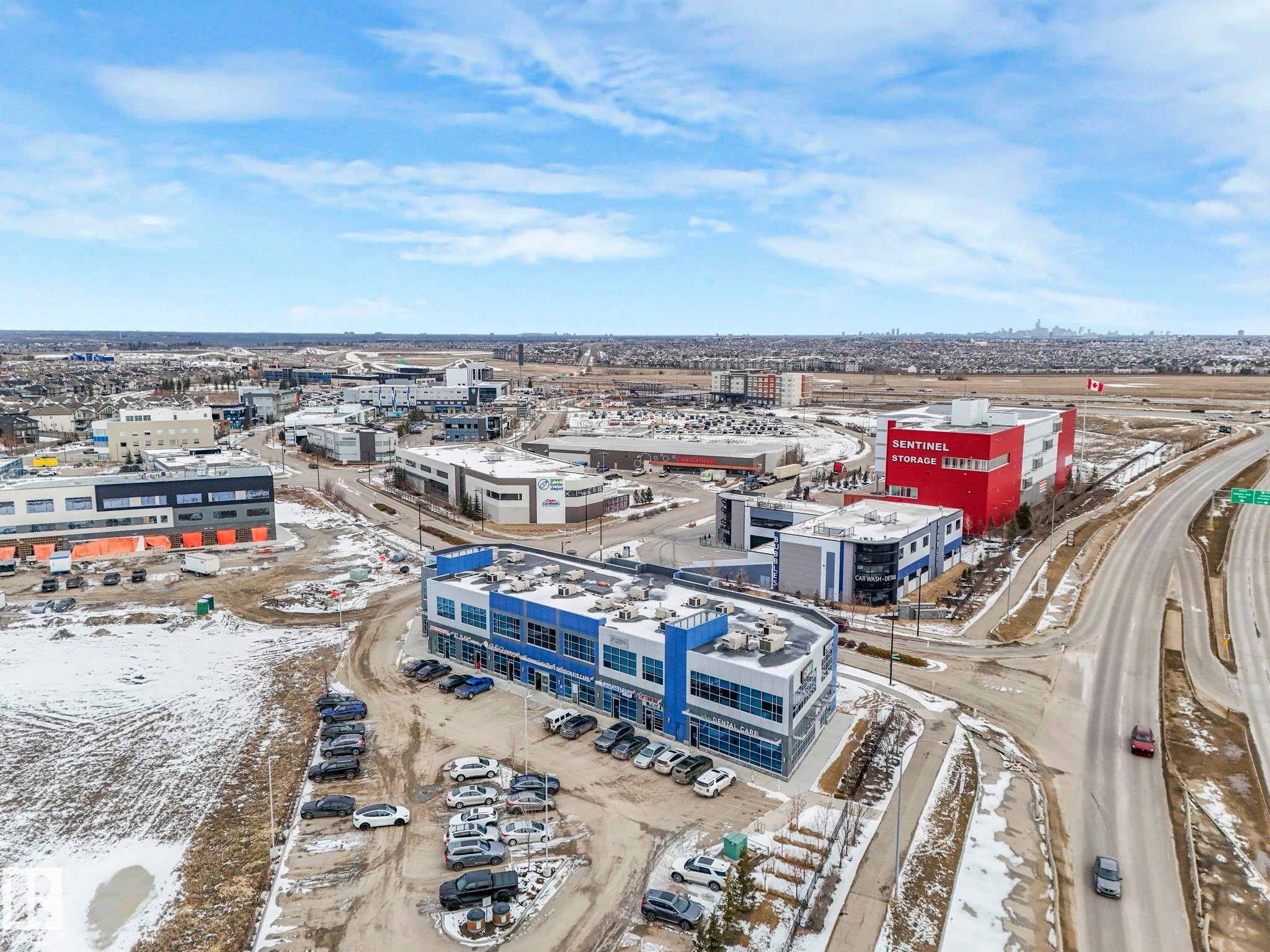 Aerial view showcasing the property's surrounding commercial buildings, roads, and distant cityscape - 95 1010 Rabbit Hill Road, Edmonton, AB - Outdoor With View