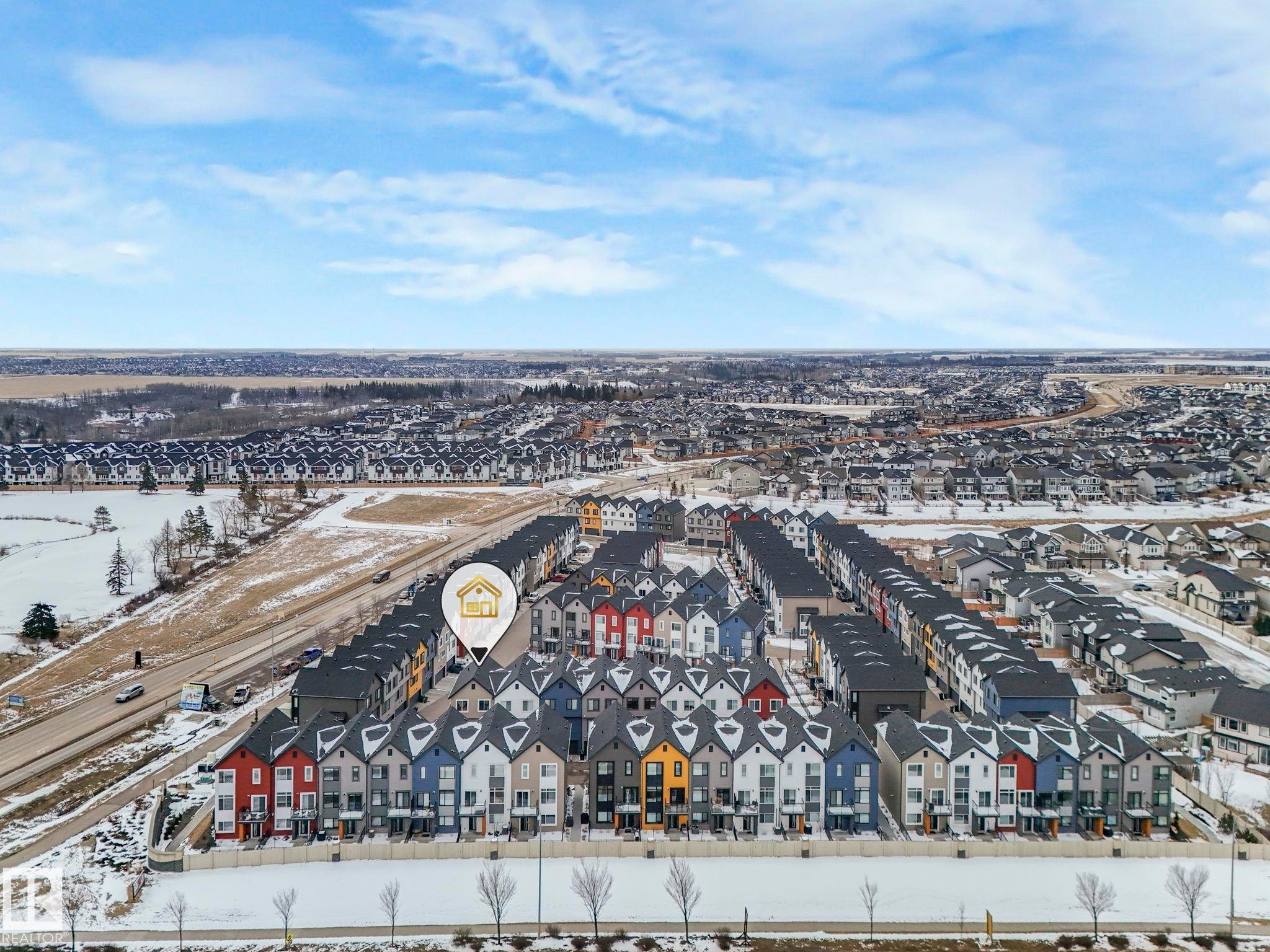 Aerial view of the community, showcasing a broad residential area with numerous properties and a road running alongside - 95 1010 Rabbit Hill Road, Edmonton, AB - Outdoor With View