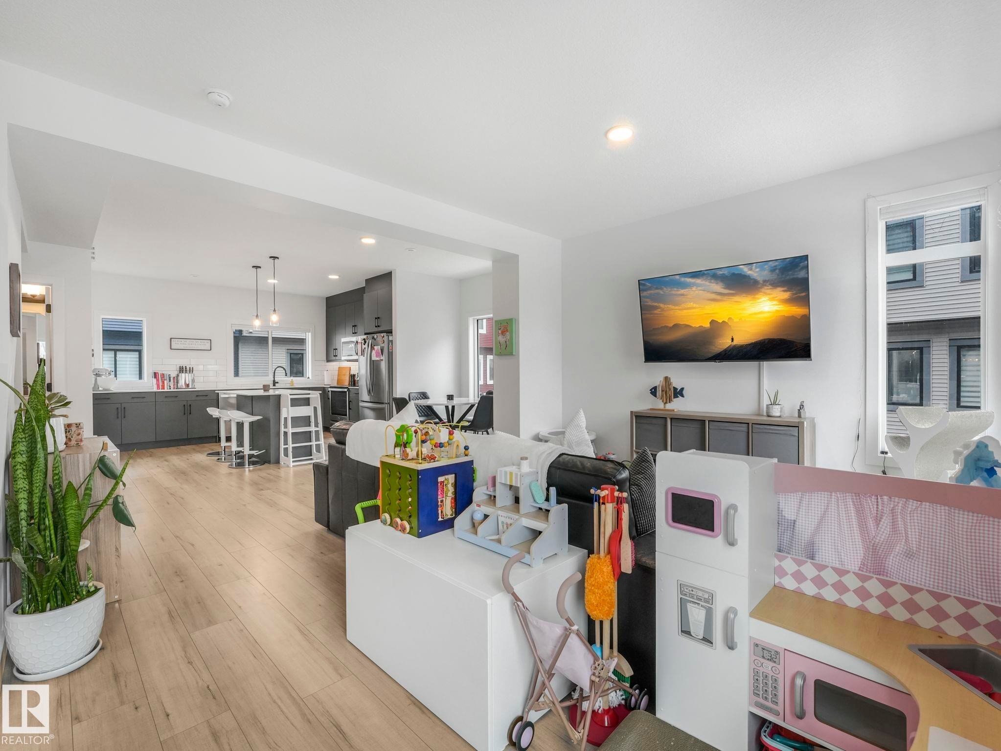 The property features an open concept living area with light-toned flooring, recessed lighting, and a modern kitchen - 95 1010 Rabbit Hill Road, Edmonton, AB - Indoor