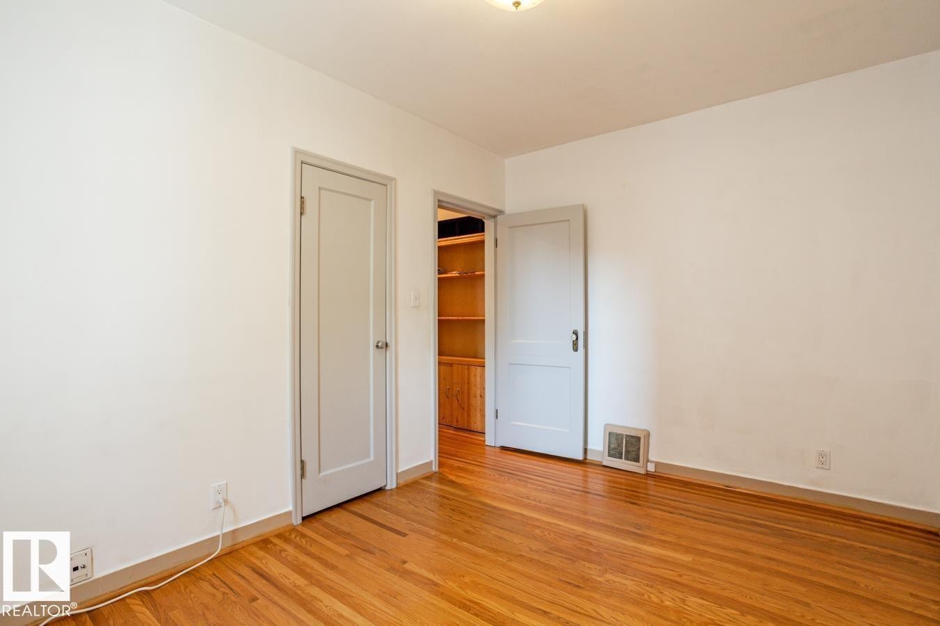 This room features hardwood floors and white walls - 8736 76 Avenue, Edmonton, AB - Indoor Photo Showing Other Room