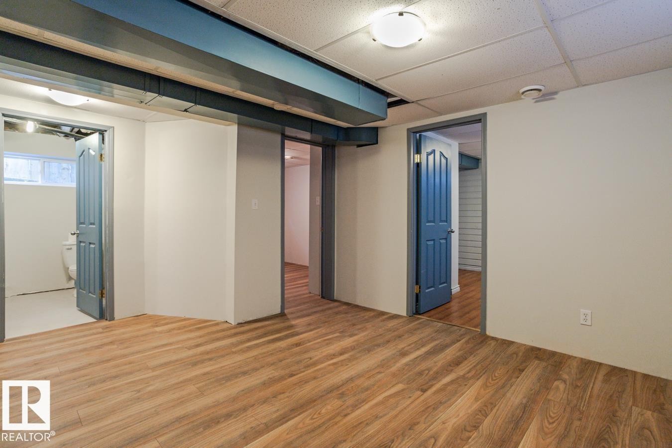 This room features wood-look flooring and light-colored walls - 8736 76 Avenue, Edmonton, AB - Indoor