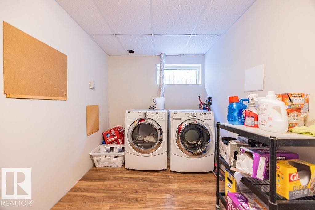 Laundry area featuring a window, wood-look flooring, and a drop ceiling - 8736 76 Avenue, Edmonton, AB - Indoor Photo Showing Laundry Room