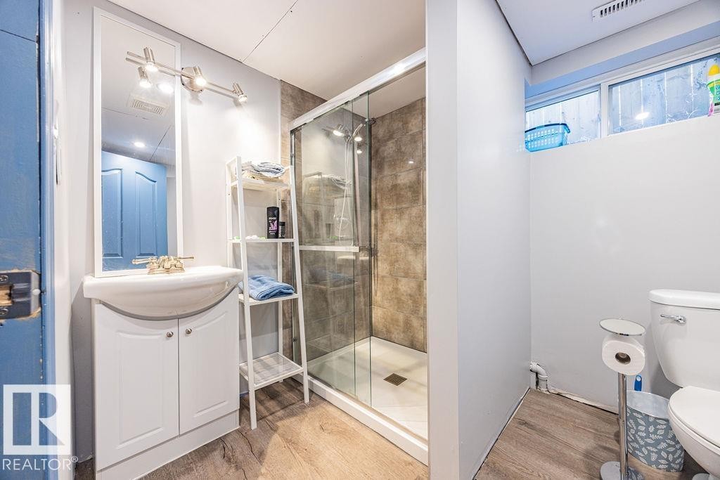 newly completed---Bathroom featuring a shower with glass enclosure, a white vanity with an integrated sink, and light-toned flooring - 8736 76 Avenue, Edmonton, AB - Indoor Photo Showing Bathroom