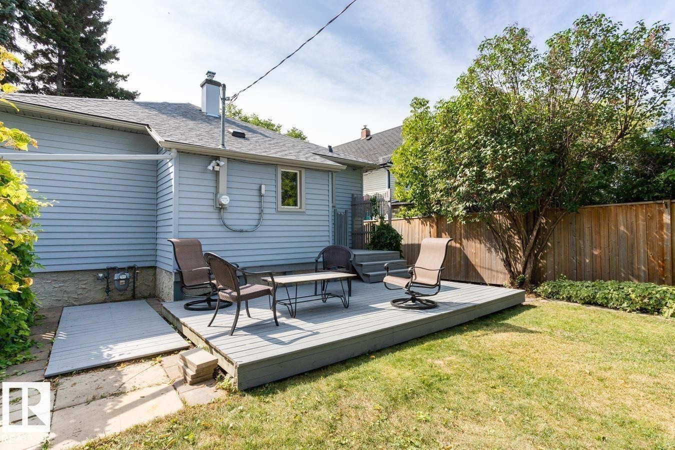 The property features a spacious deck with steps leading to a well-maintained lawn - 8736 76 Avenue, Edmonton, AB - Outdoor With Deck Patio Veranda With Exterior