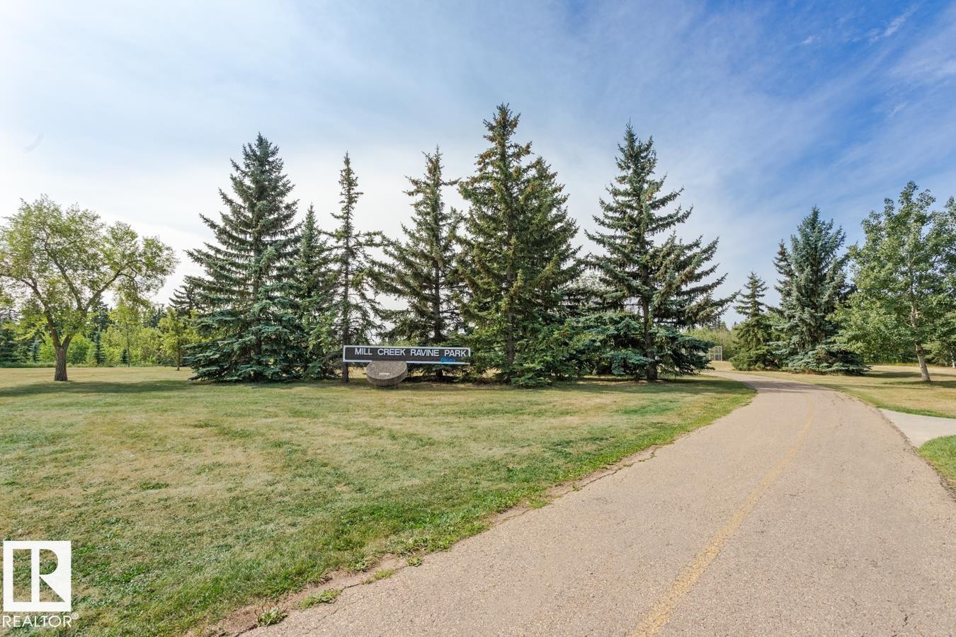 The property is located within a scenic park setting, featuring mature evergreen trees and expansive green spaces - 8736 76 Avenue, Edmonton, AB - Outdoor With View