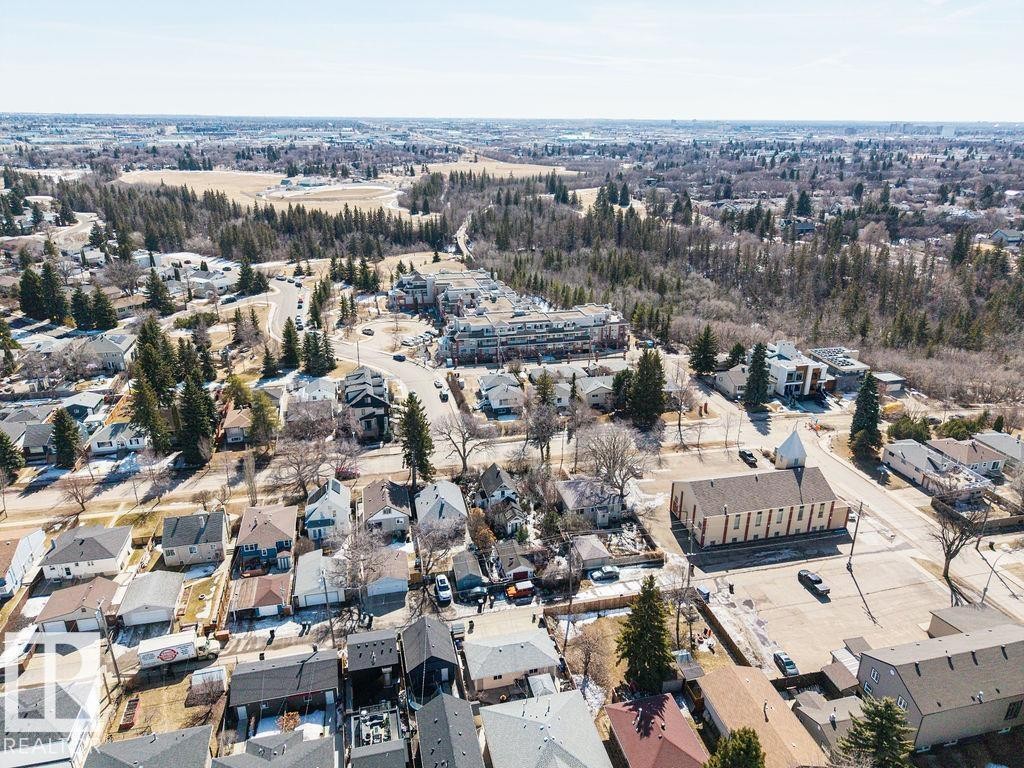 An aerial view of the surrounding neighborhood, featuring a mix of residential properties, mature trees, and paved roads - 8736 76 Avenue, Edmonton, AB - Outdoor With View