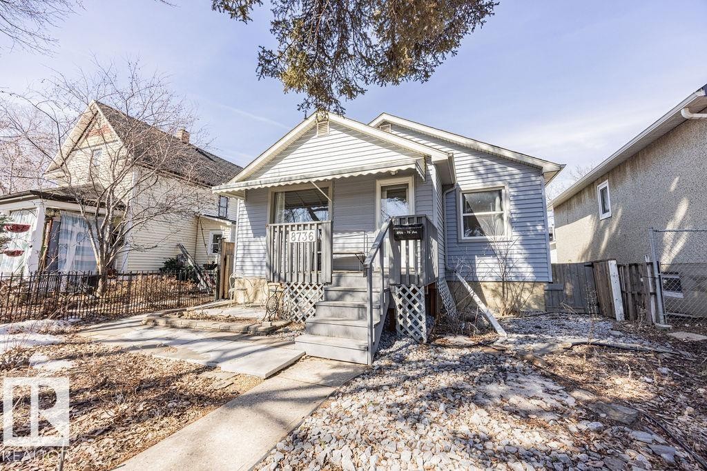 This property features a front porch with an awning, a concrete walkway, and a gravel front yard - 8736 76 Avenue, Edmonton, AB - Outdoor
