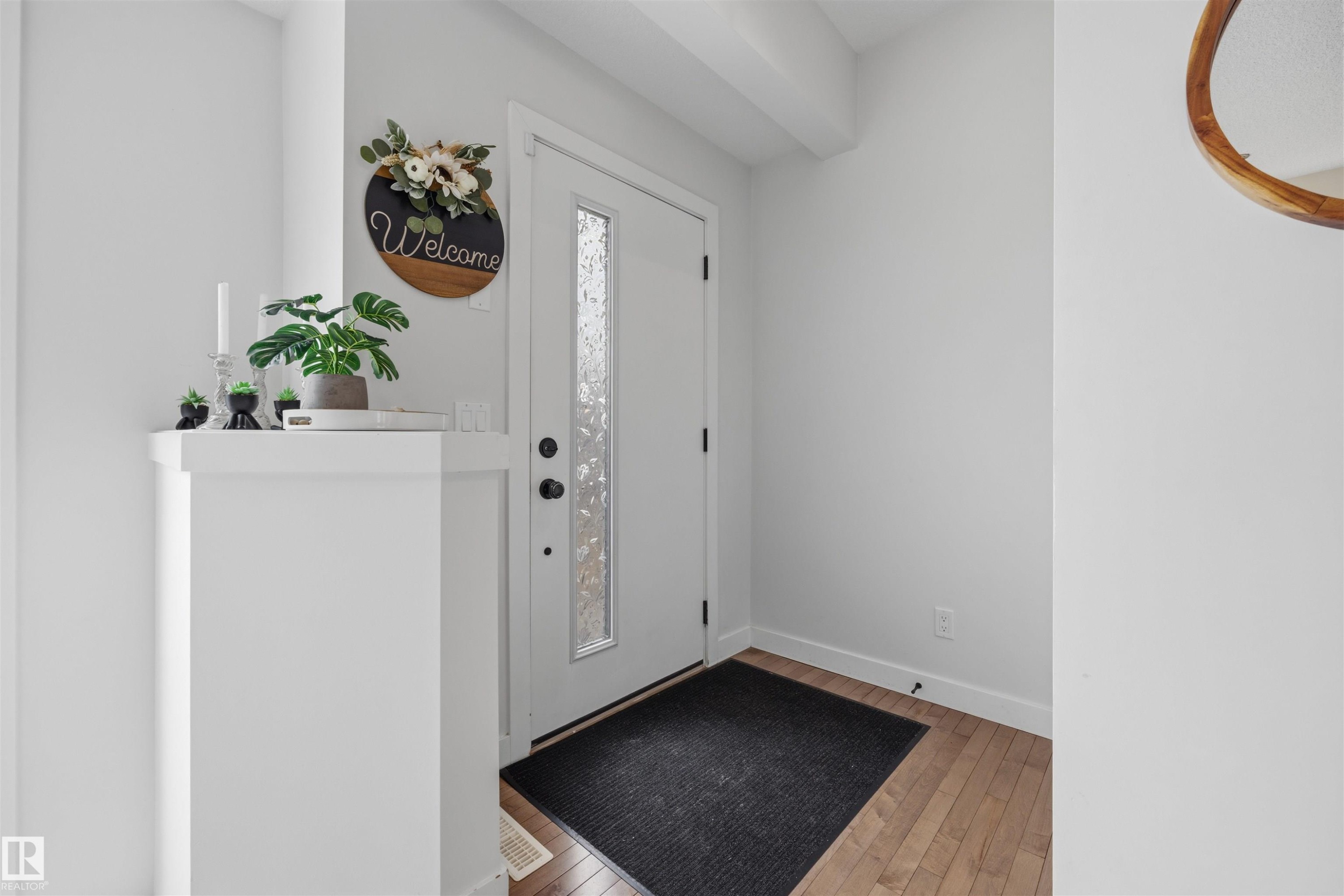 Entryway featuring a white door with a textured glass insert, hardwood flooring, and light-colored walls - 7123 Cardinal Way, Edmonton, AB - Indoor Photo Showing Other Room
