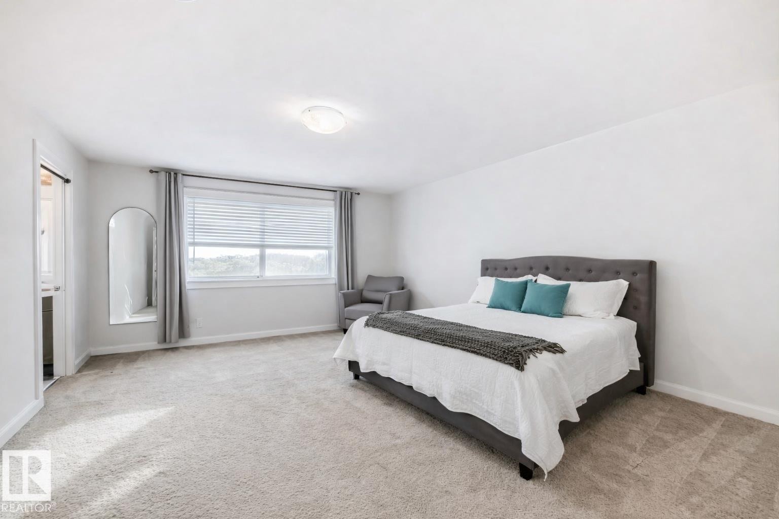 Spacious room featuring light-colored carpeting, white walls, a large window with blinds and drapes, and an overhead light fixture - 2935 Chokecherry Common, Edmonton, AB - Indoor Photo Showing Bedroom