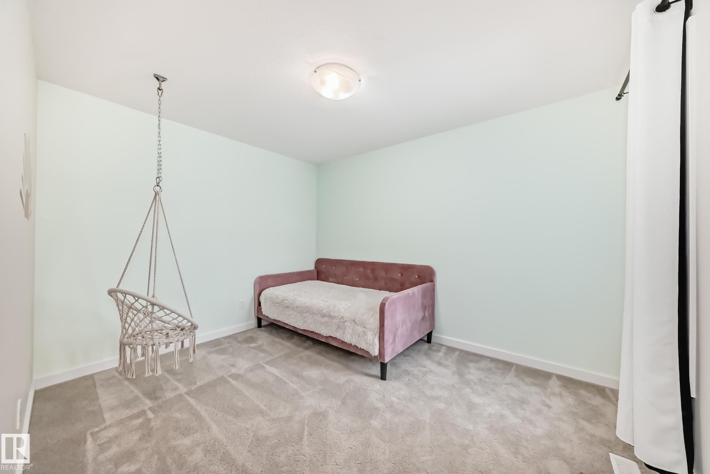 This room features light-colored walls and grey carpet, creating a neutral backdrop - 2935 Chokecherry Common, Edmonton, AB - Indoor Photo Showing Other Room