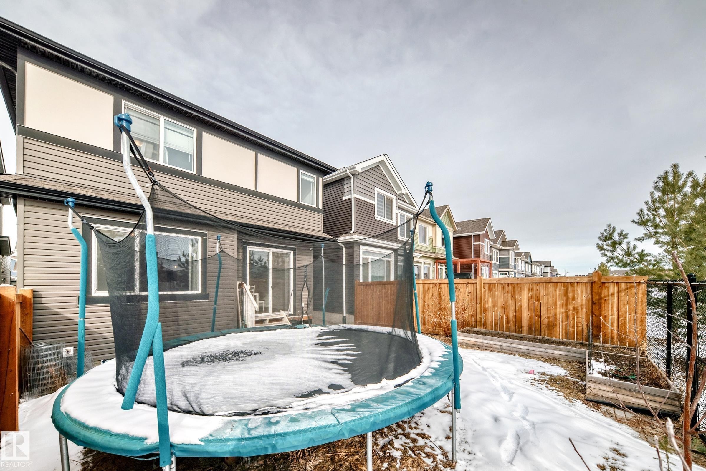 The property features a fenced backyard with a patio area and a wooden fence - 2935 Chokecherry Common, Edmonton, AB - Outdoor