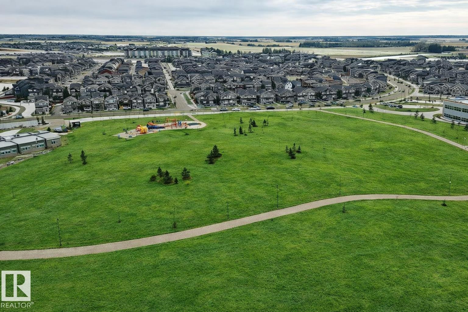 Expansive green space with walking paths, mature trees, and a dedicated play area, all within close proximity to residential developments - 2935 Chokecherry Common, Edmonton, AB - Outdoor With View