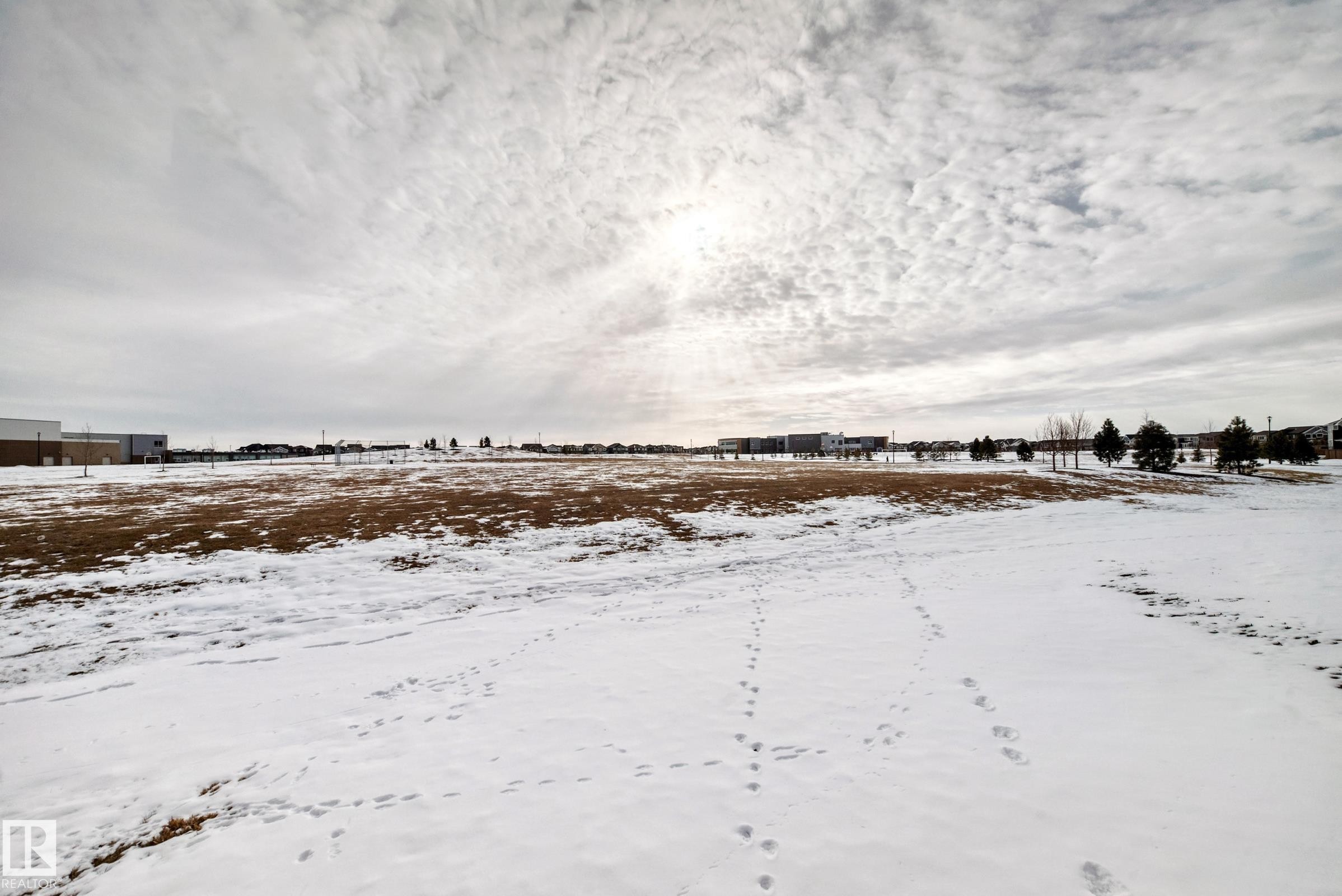 Expansive undeveloped land area featuring a mix of snow-covered ground and visible patches of brown vegetation - 2935 Chokecherry Common, Edmonton, AB - Outdoor With View