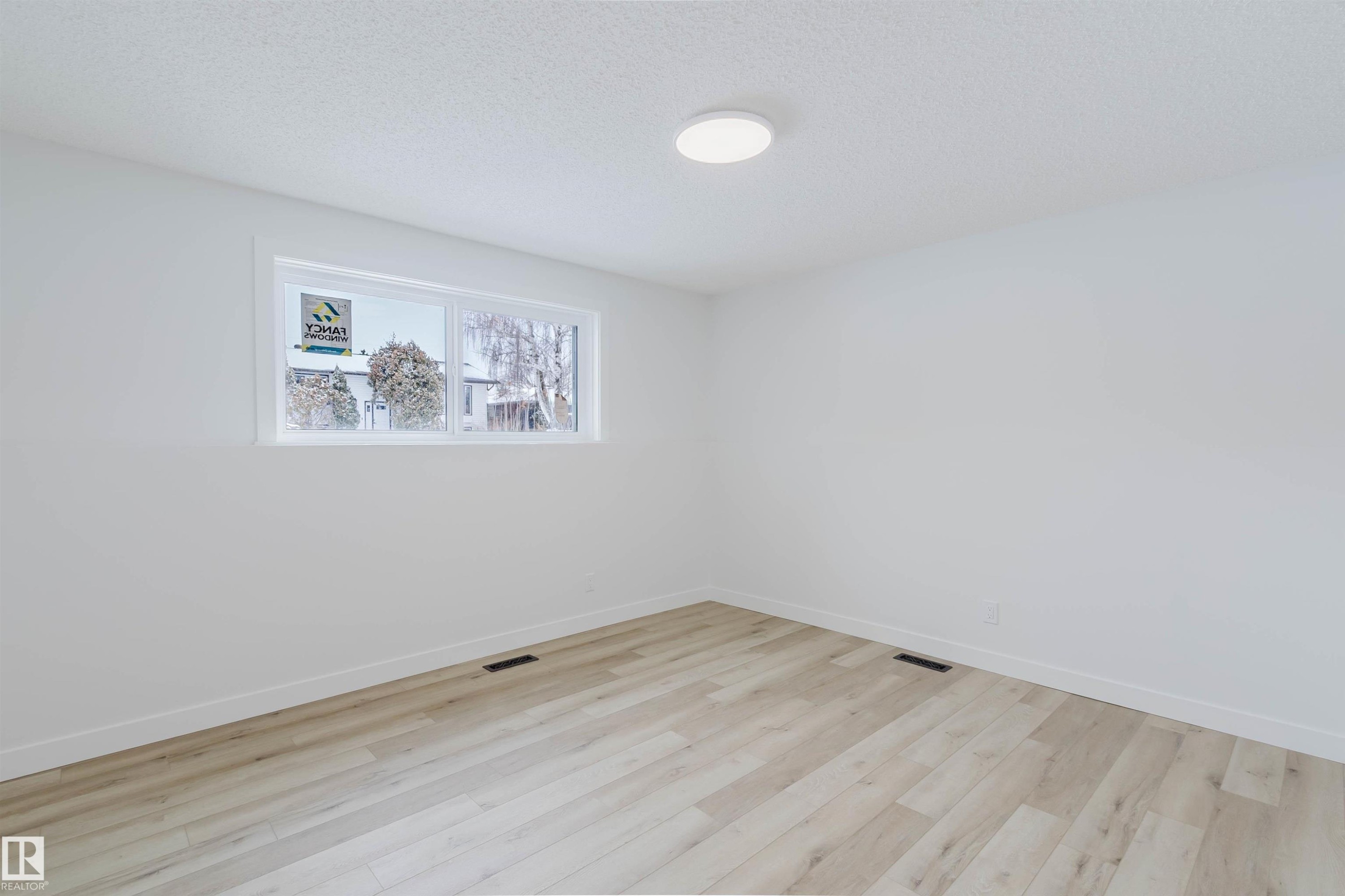 This room features light-colored flooring, white walls, and a window providing natural light - 11528 42 Avenue, Edmonton, AB - Indoor Photo Showing Other Room