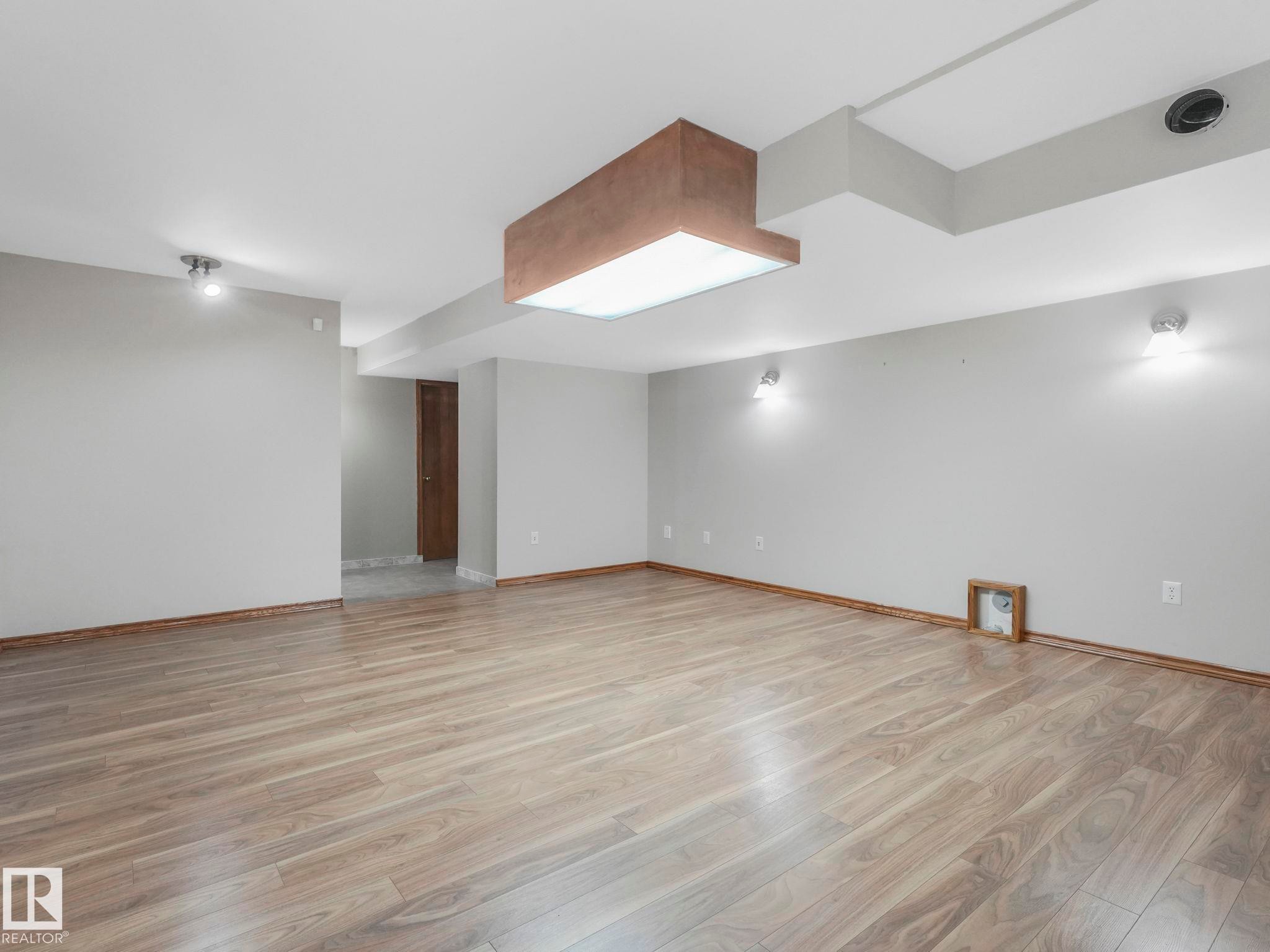 The property features light wood flooring, neutral-toned walls, and a variety of ceiling-mounted lighting fixtures - 11704 11 Avenue, Edmonton, AB - Indoor Photo Showing Other Room