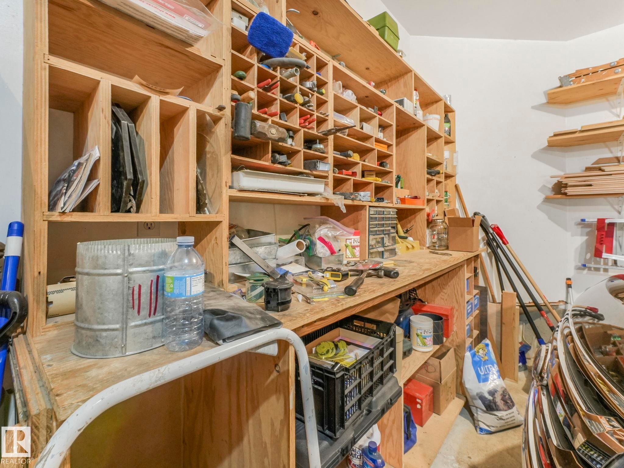 The property includes a dedicated workspace with extensive wooden shelving and a workbench - 11704 11 Avenue, Edmonton, AB - Indoor
