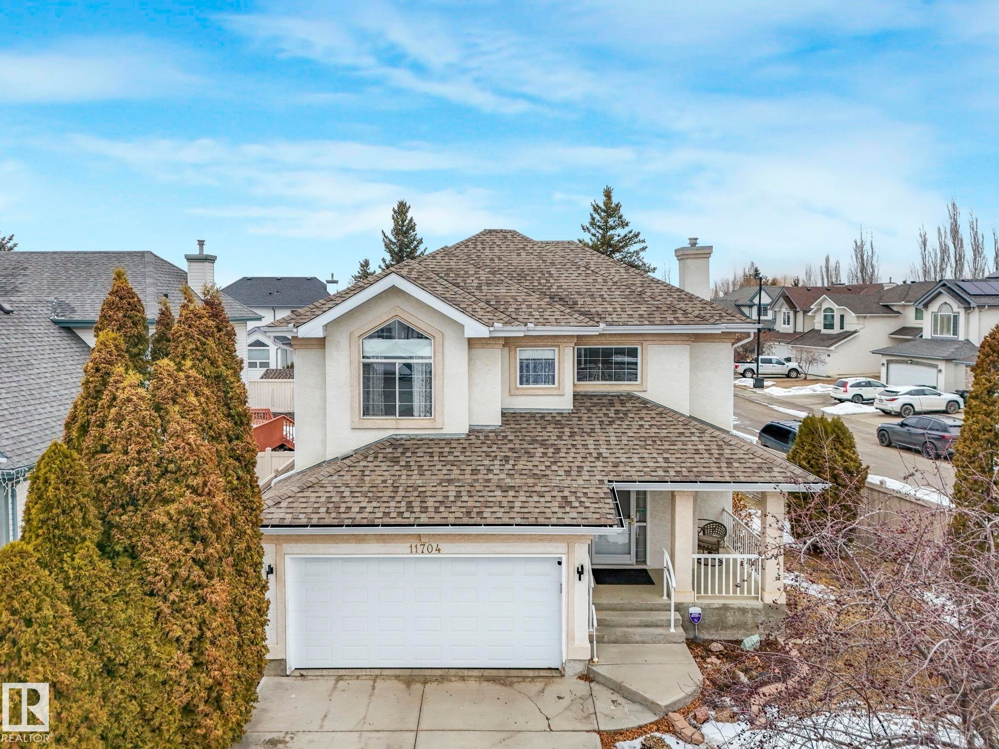 This property features a light-colored exterior, a shingled roof, and an attached garage with a white door - 11704 11 Avenue, Edmonton, AB - Outdoor With Facade