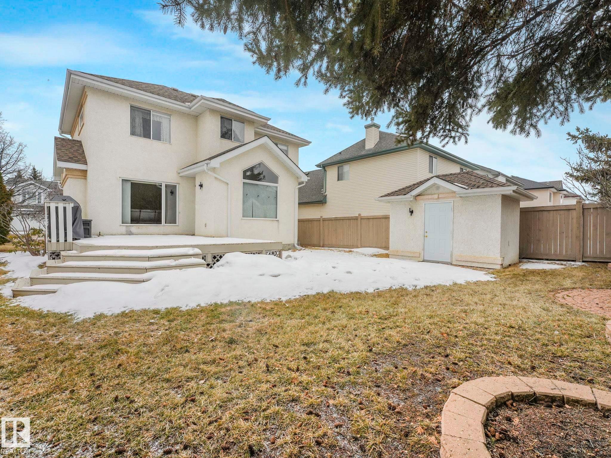 The property features a spacious backyard with a deck and steps, a dedicated storage shed, and a stone-edged garden area - 11704 11 Avenue, Edmonton, AB - Outdoor