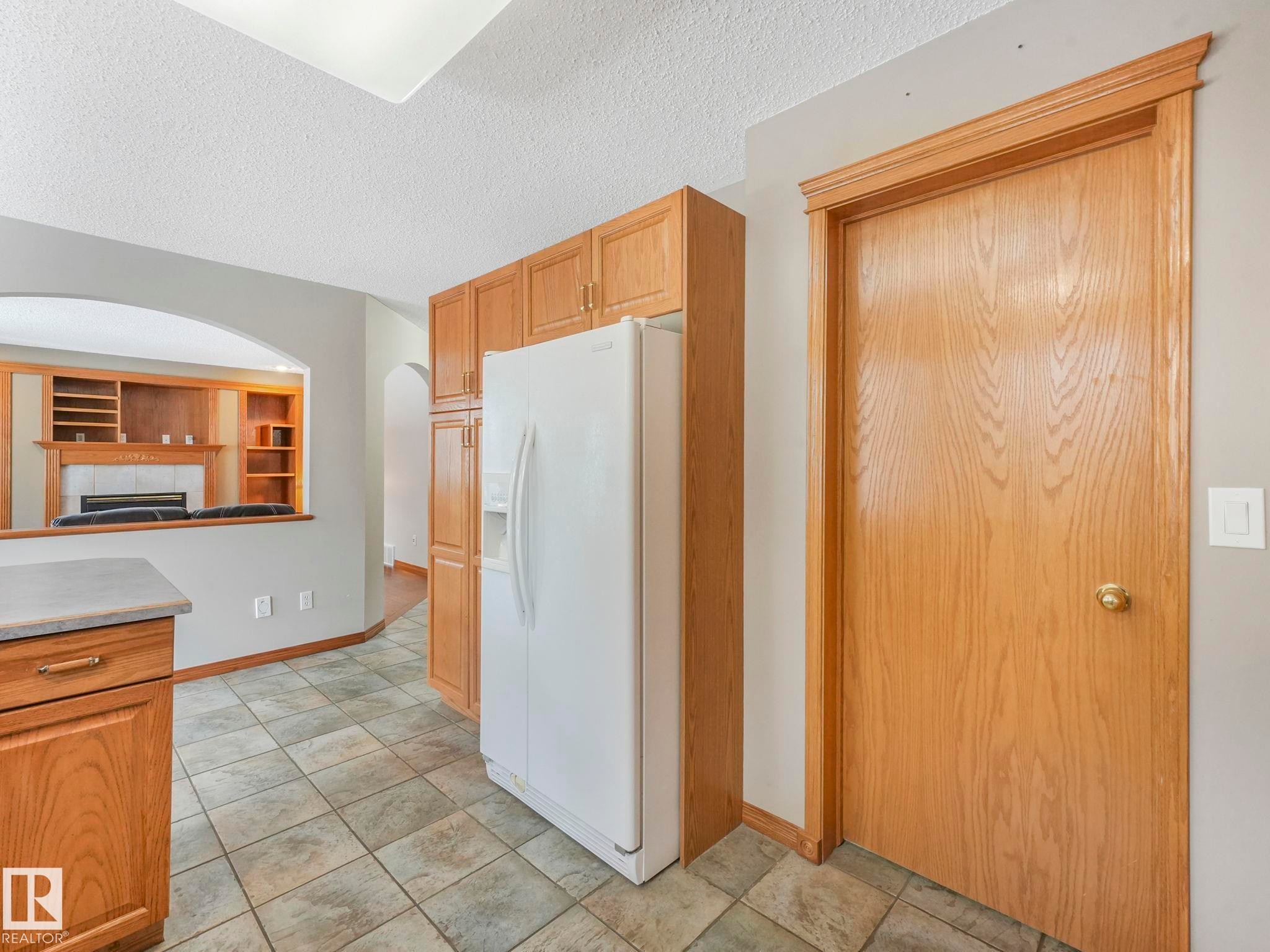 Kitchen area with tile flooring and wood cabinetry - 11704 11 Avenue, Edmonton, AB - Indoor Photo Showing Kitchen
