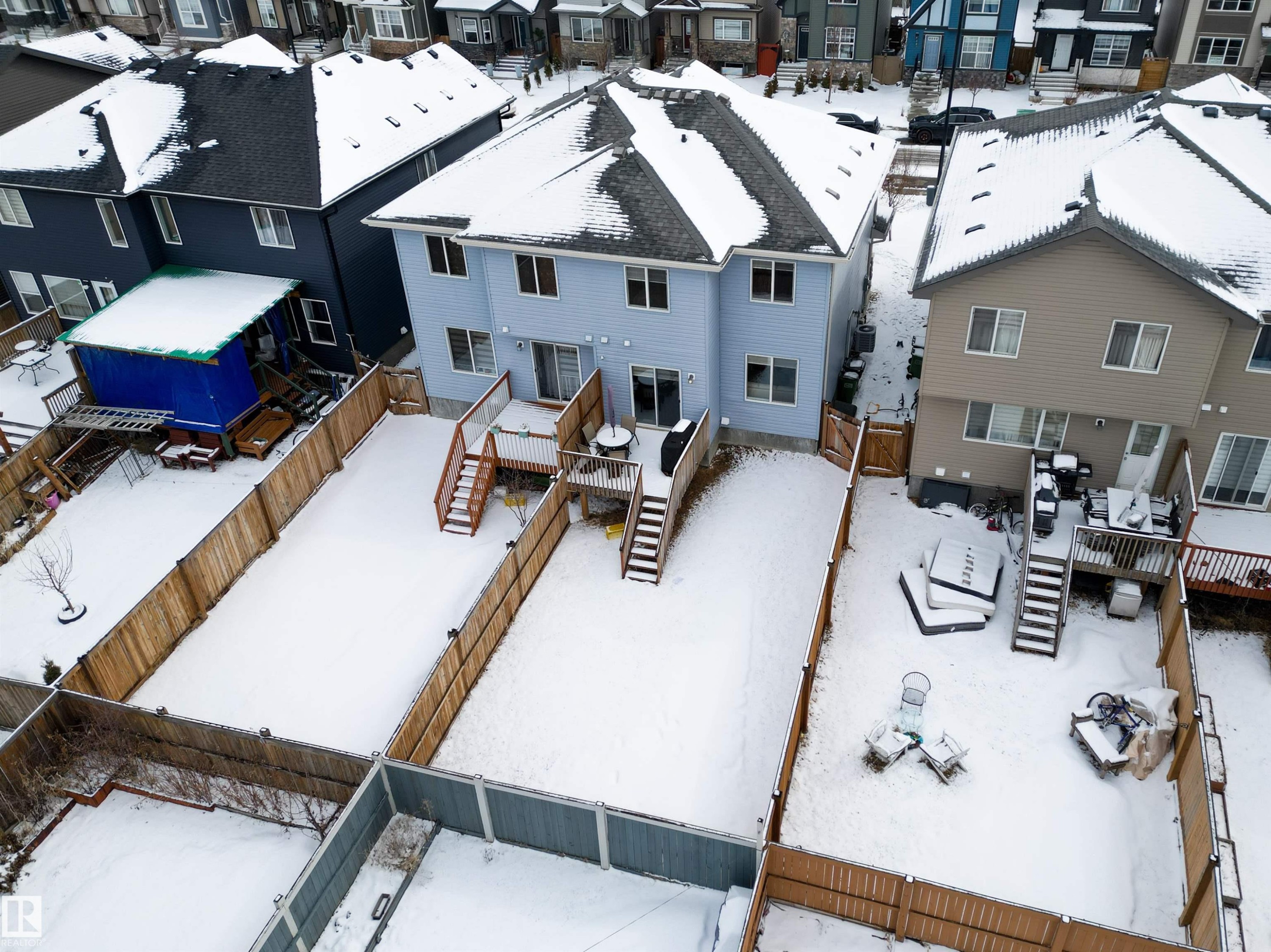 The property features a light blue exterior, a dark roof, and a wooden deck - 2132 52 St, Edmonton, AB - Outdoor With Deck Patio Veranda