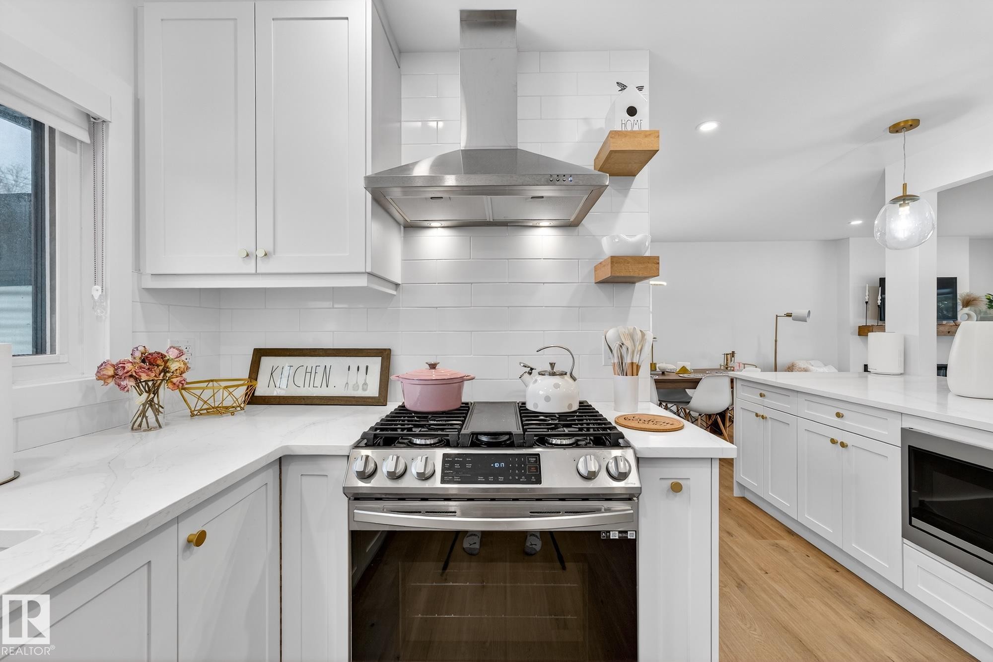 Kitchen featuring stainless steel appliances, exhaust hood, light stone counters, and white cabinetry - 8604 142 Street, Edmonton, AB - Indoor Photo Showing Kitchen