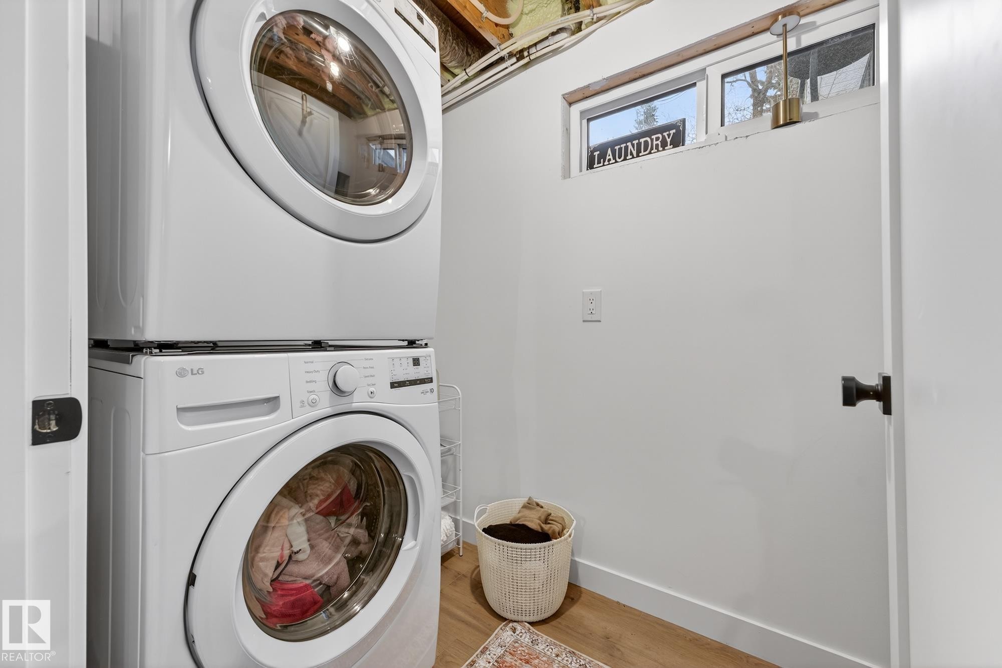 Laundry area featuring stacked washer / dryer and light wood-style flooring - 8604 142 Street, Edmonton, AB - Indoor Photo Showing Laundry Room