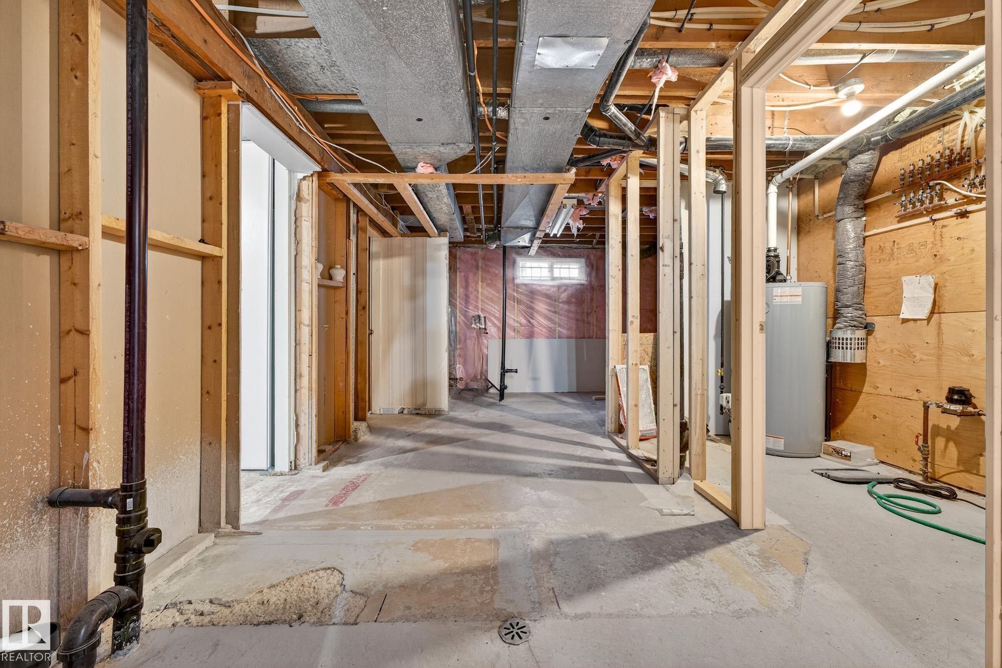 Unfinished basement with water heater - 8604 142 Street, Edmonton, AB - Indoor Photo Showing Basement