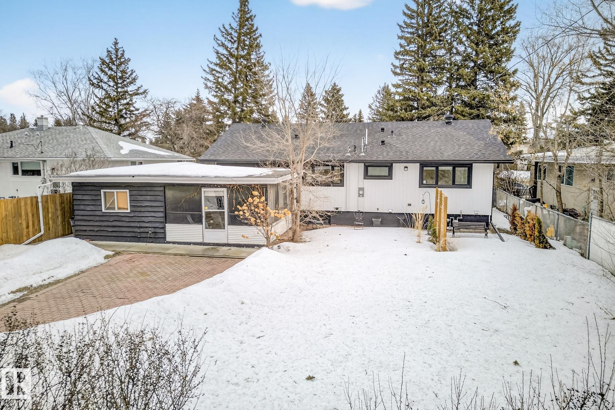 Snow covered rear of property with a sunroom - 8604 142 Street, Edmonton, AB - Outdoor