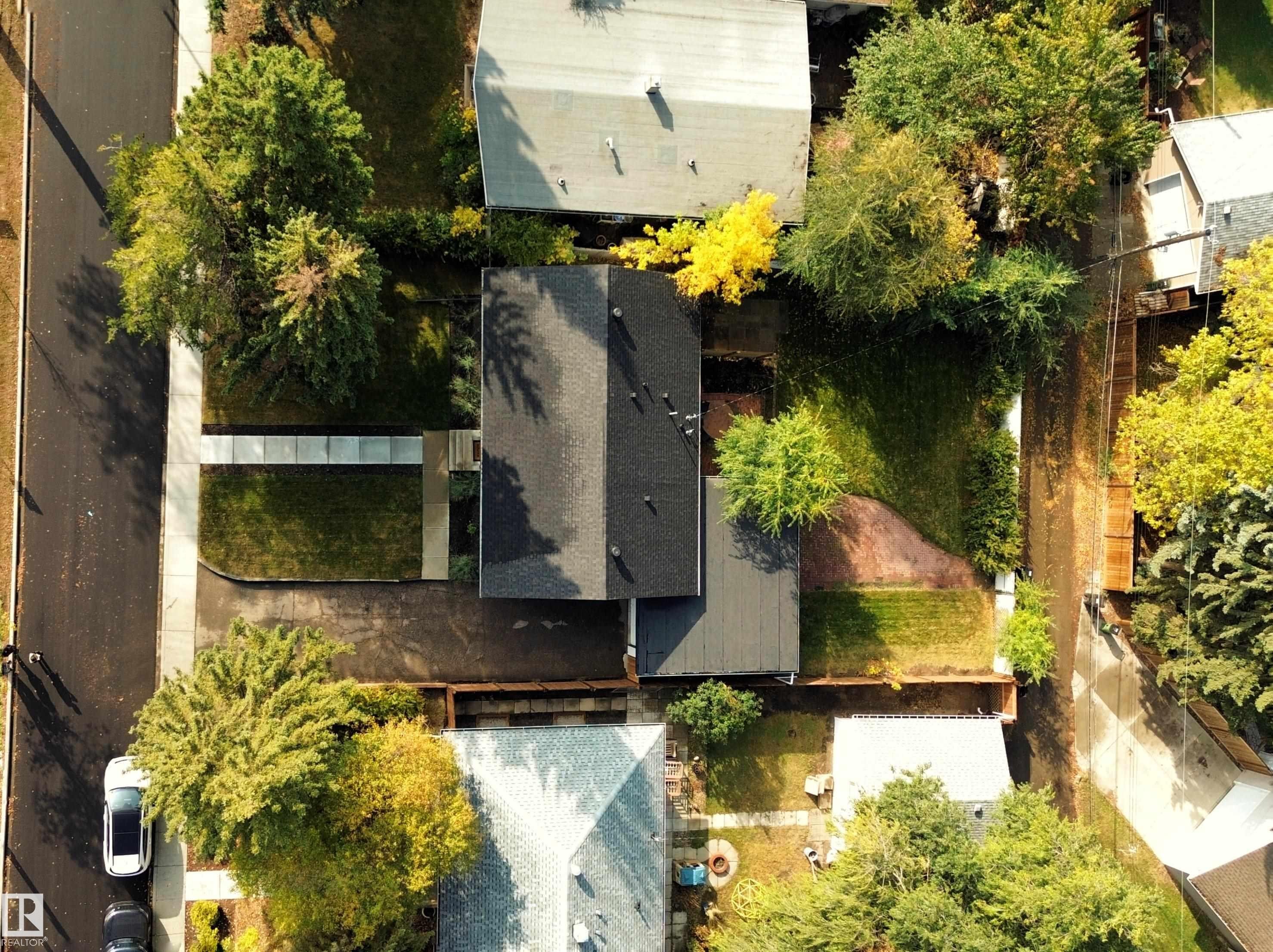 Aerial view of the property featuring a dark-colored roof, a well-maintained lawn, and mature trees - 8604 142 Street, Edmonton, AB - Outdoor