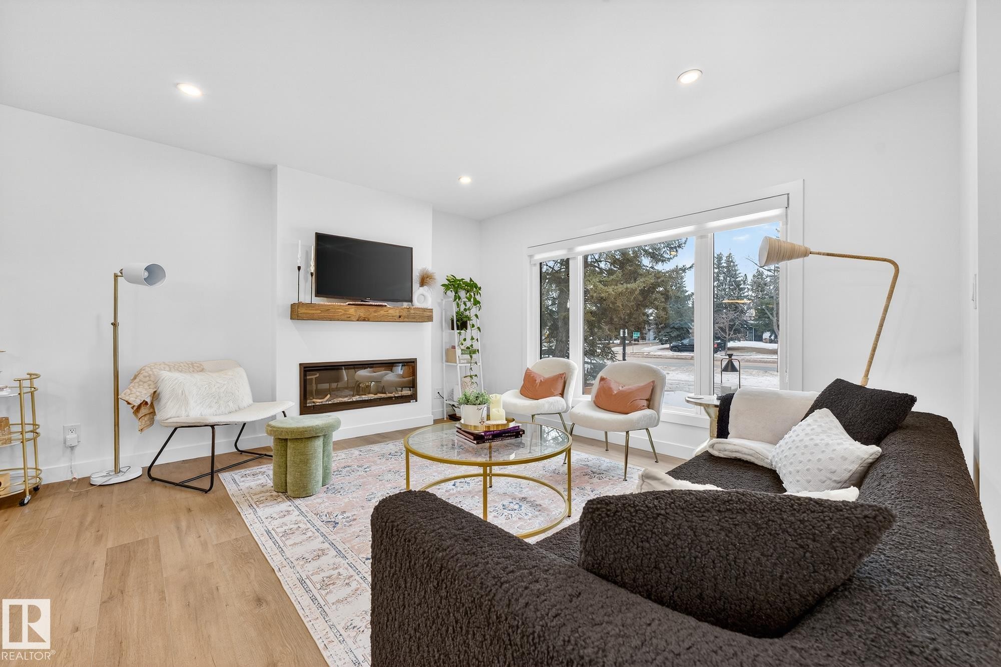 Living room with a glass covered fireplace, recessed lighting, and light wood-style flooring - 8604 142 Street, Edmonton, AB - Indoor Photo Showing Living Room With Fireplace